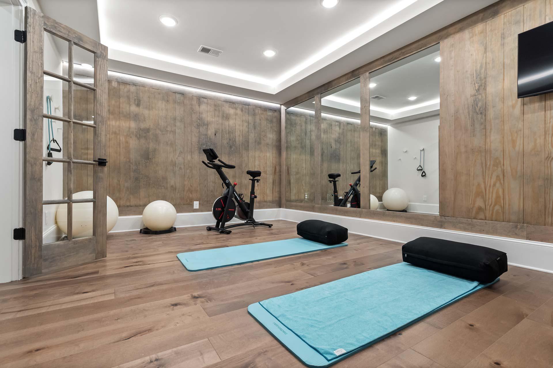 Spacious home gym with shiplap walls, mirrors, spin bike, yoga mats, blocks and exercise balls at Tanglewood in East Cobb, Georgia