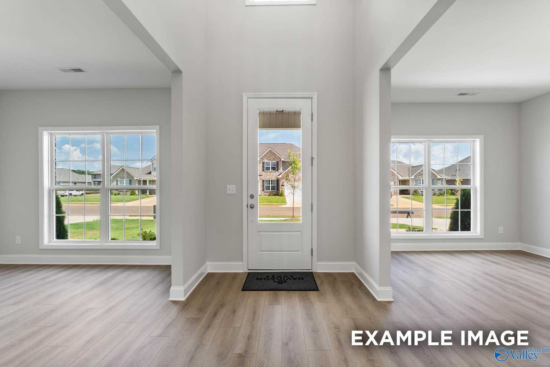 Grand entry foyer with vaulted ceiling, large windows, and neighborhood view in Davidson Homes The Madison A, Harvest, Alabama