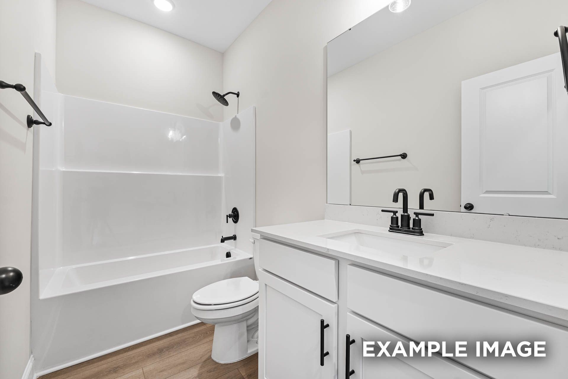 Modern bathroom with white vanity, quartz countertop, and tub-shower combo in The Franklin E floor plan, Fayetteville, TN.