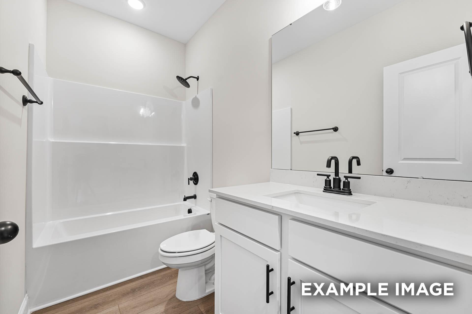 Modern bathroom with white vanity, quartz countertop, and tub-shower combo in The Franklin E floor plan, Fayetteville, TN.