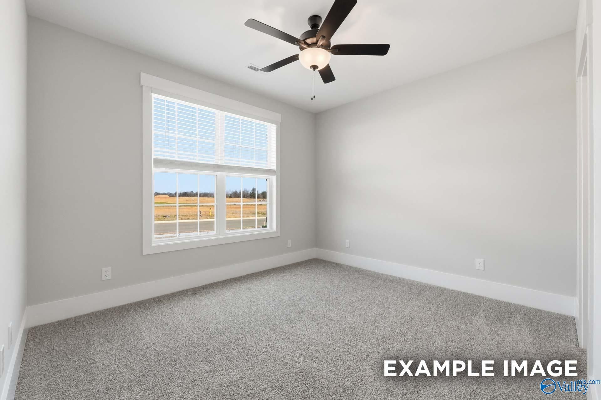Bright bedroom with neutral carpet and ceiling fan in The Rockford floor plan by Davidson Homes in Briercreek, Meridianville.