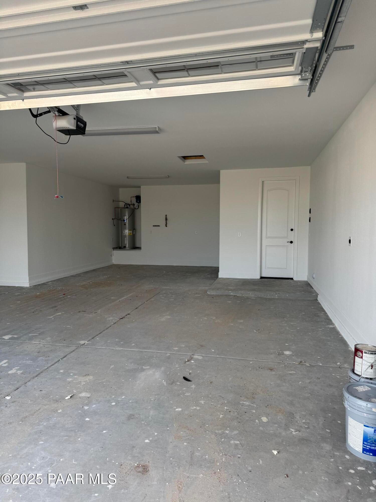 Spacious 4-car garage with white walls, open doors, and concrete floor in Evermore Homes The Sunrise A, Prescott Valley, Arizona
