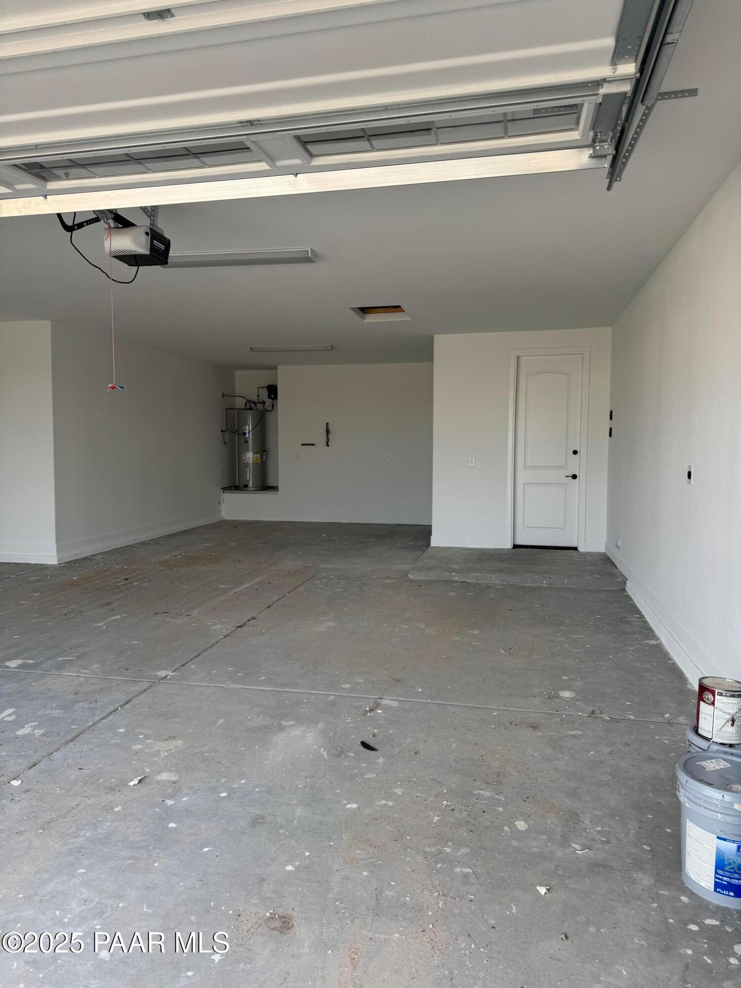 Spacious 4-car garage with white walls, open doors, and concrete floor in Evermore Homes The Sunrise A, Prescott Valley, Arizona