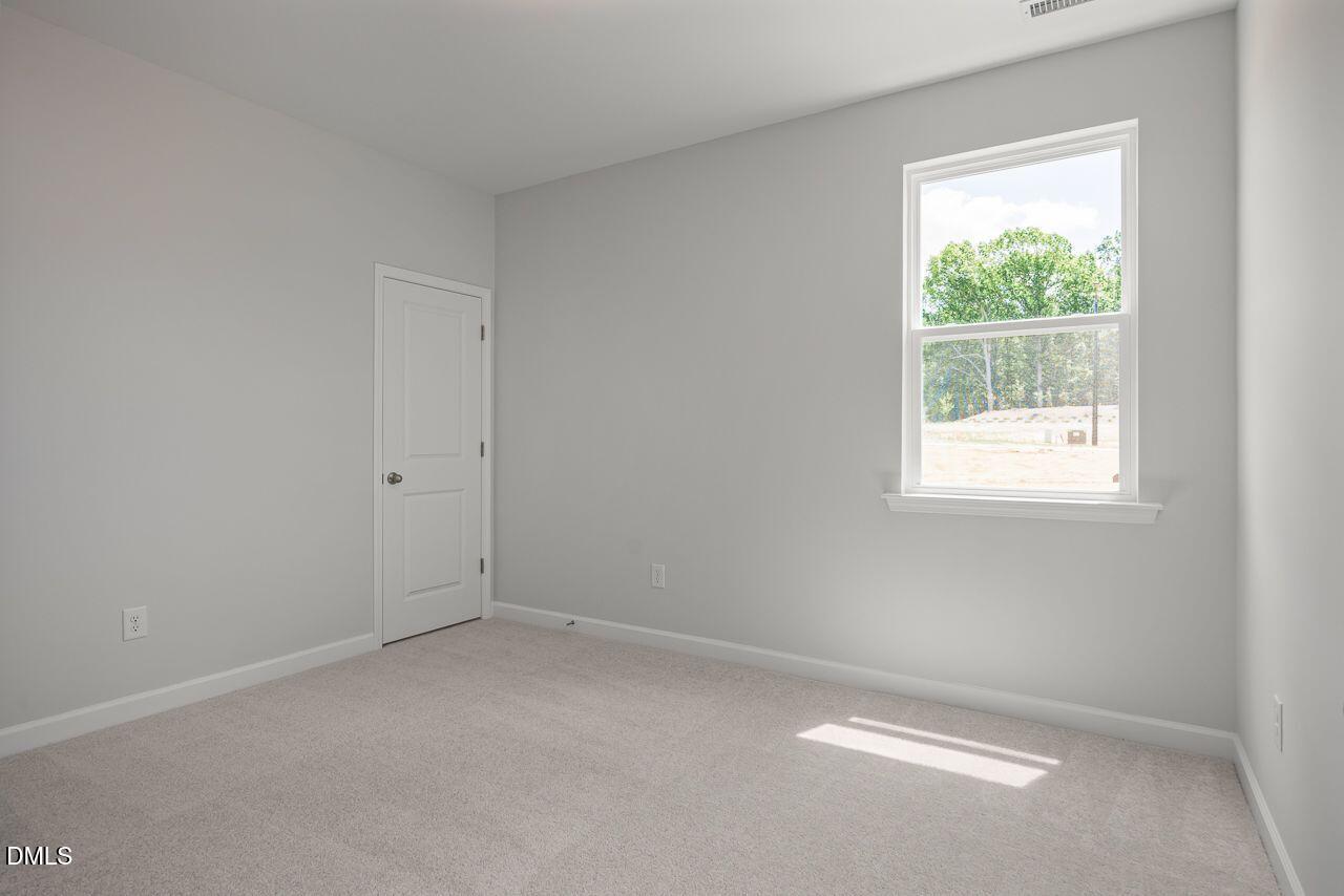 Bright secondary bedroom with neutral carpet in The Birch II A floor plan by Davidson Homes in Montrose, Aberdeen, NC.