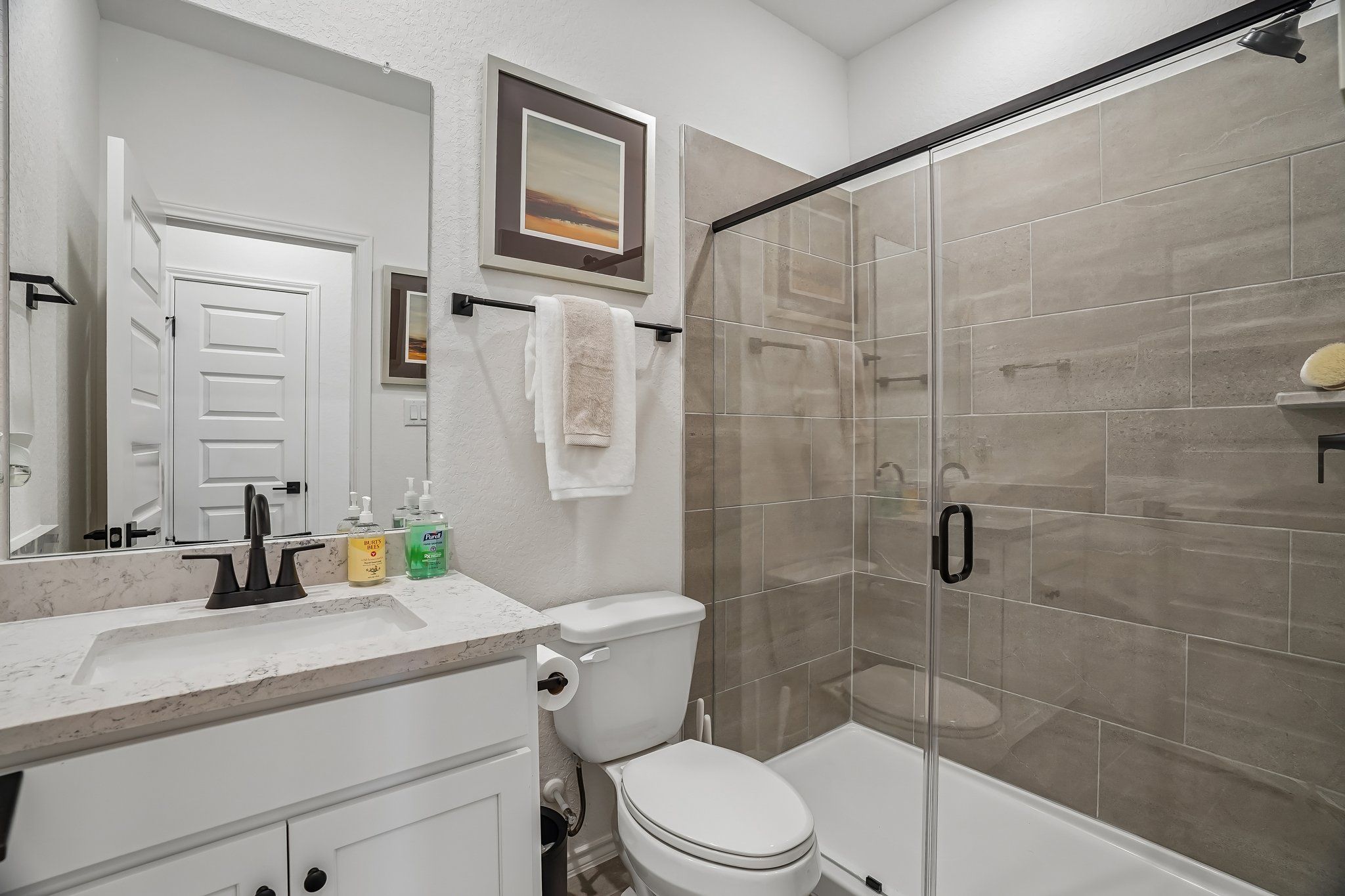 Modern bathroom with glass-enclosed tiled shower and vanity at Fairway Crossing by Davidson Homes in Converse, Texas.