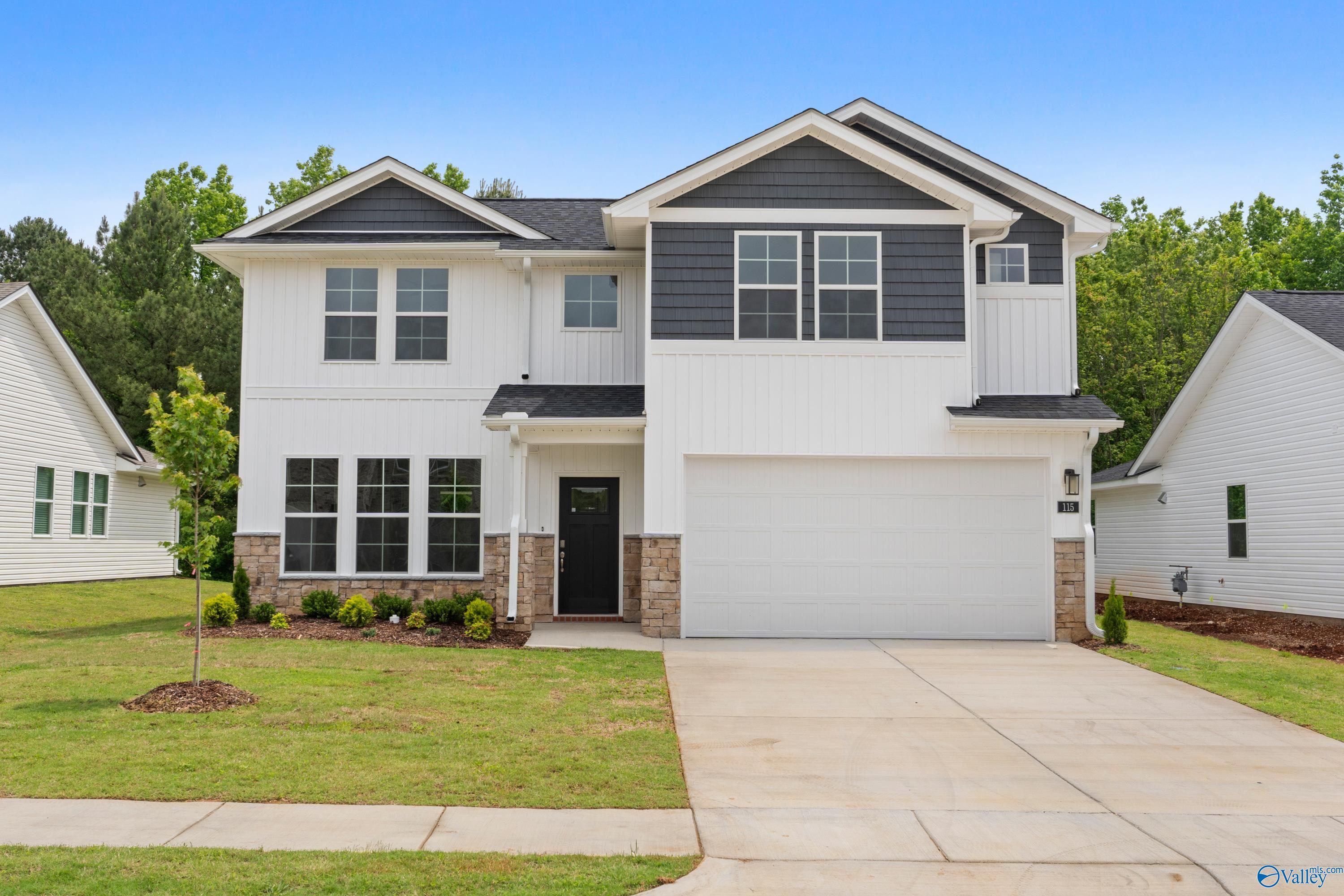 Modern two-story Davidson Homes The Stella with white siding, black accents, two-car garage in Forest Glen, Hazel Green, Alabama