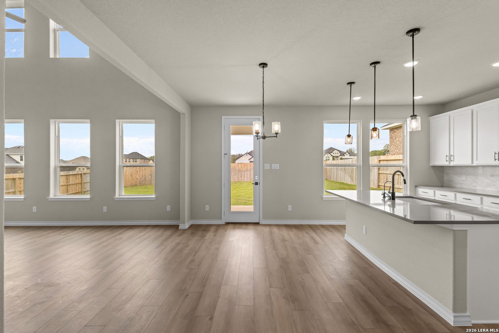 Open-concept kitchen and living area with vaulted ceilings in The Danbury H floor plan, The Reserve at Potranco Oaks.
