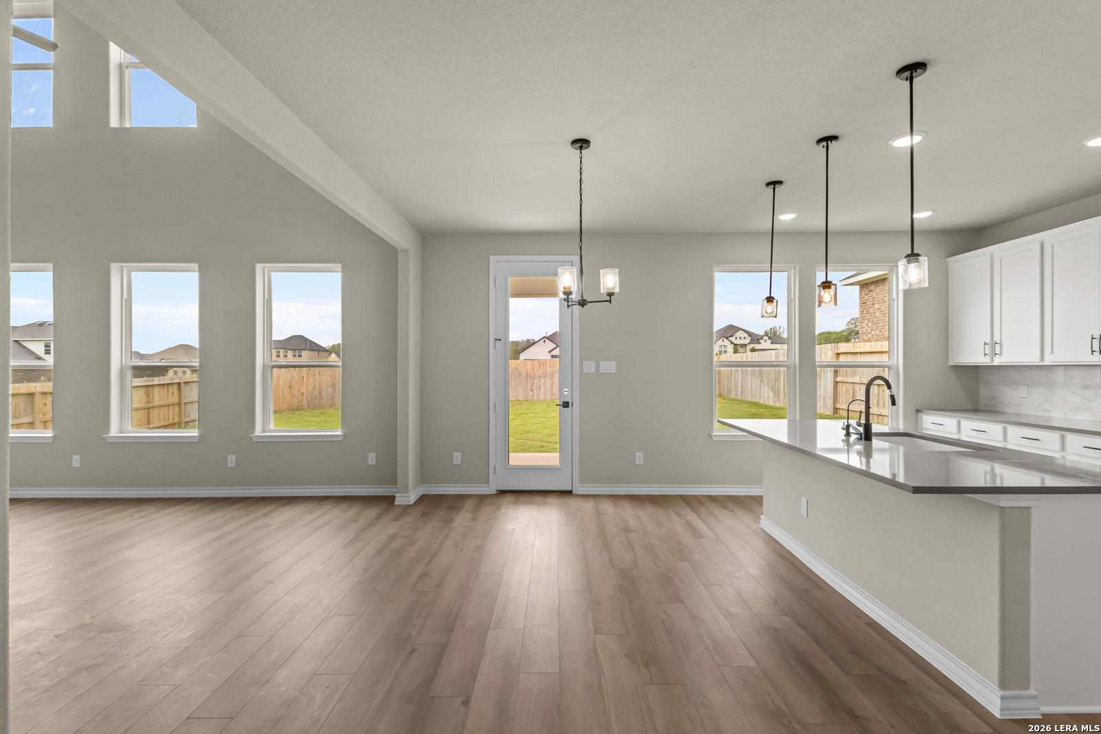 Open-concept kitchen and living area with vaulted ceilings in The Danbury H floor plan, The Reserve at Potranco Oaks.