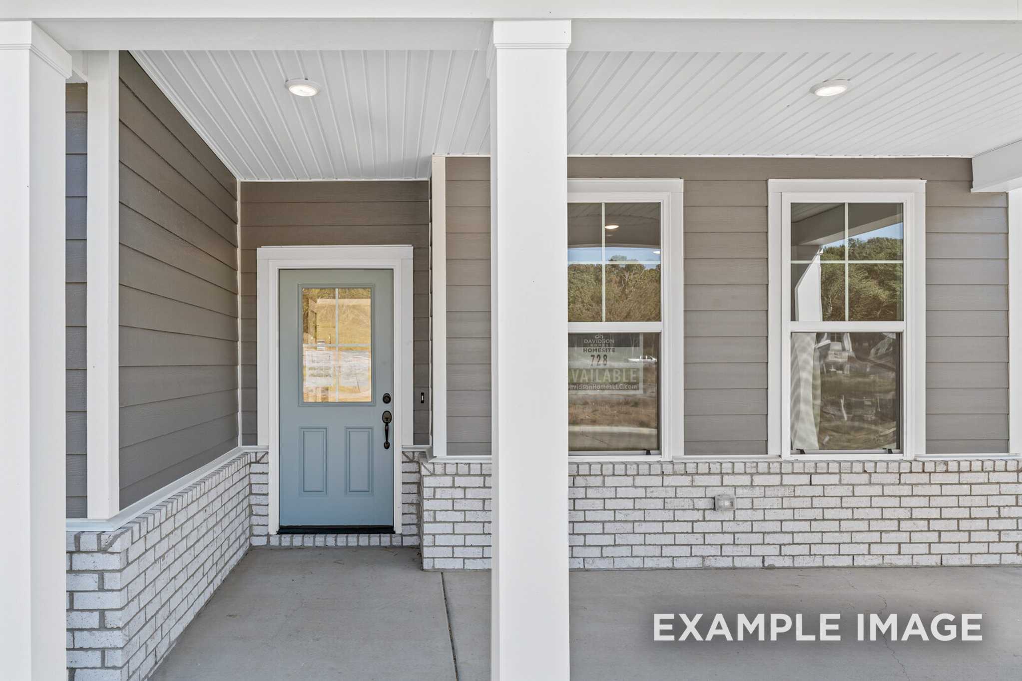 Front elevation of The Henry C 2-story home with covered porch, gray siding, white columns, brick accents, and blue glass door