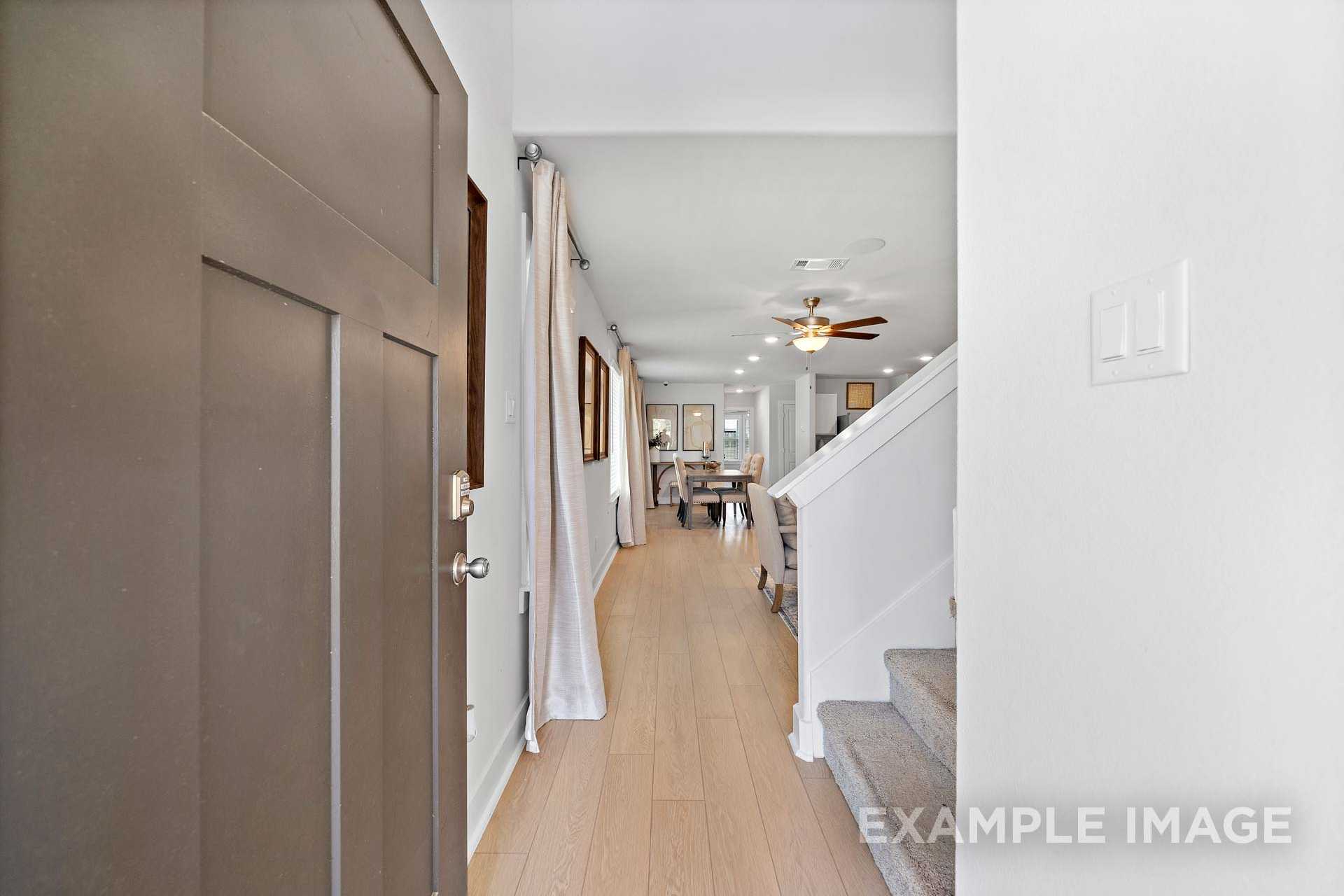 Spacious entry hallway in The Rose B 2-story home with dining area, hardwood floors, and curved staircase