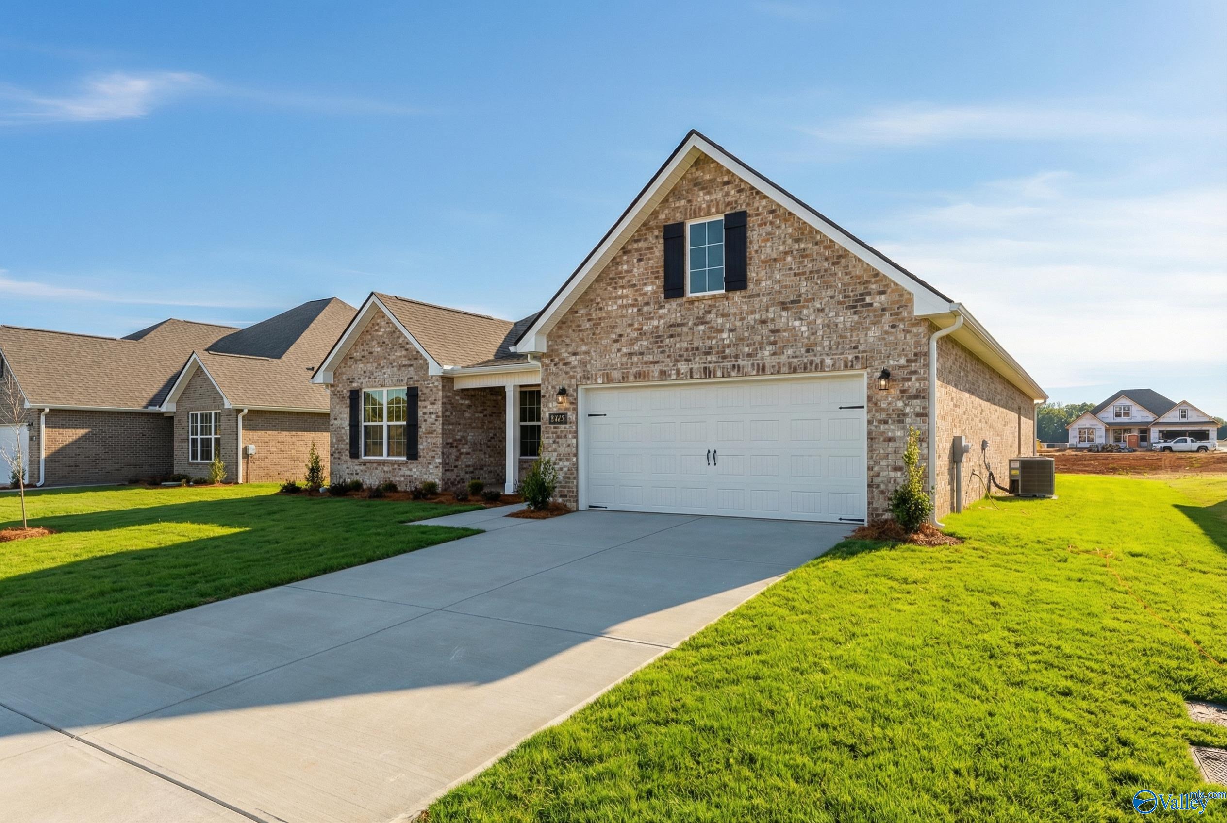 Brick single-story home with 2-car garage, front porch, driveway, and lush lawn in Pikes Ridge, Meridianville, Alabama by Davidson Homes The Rockford