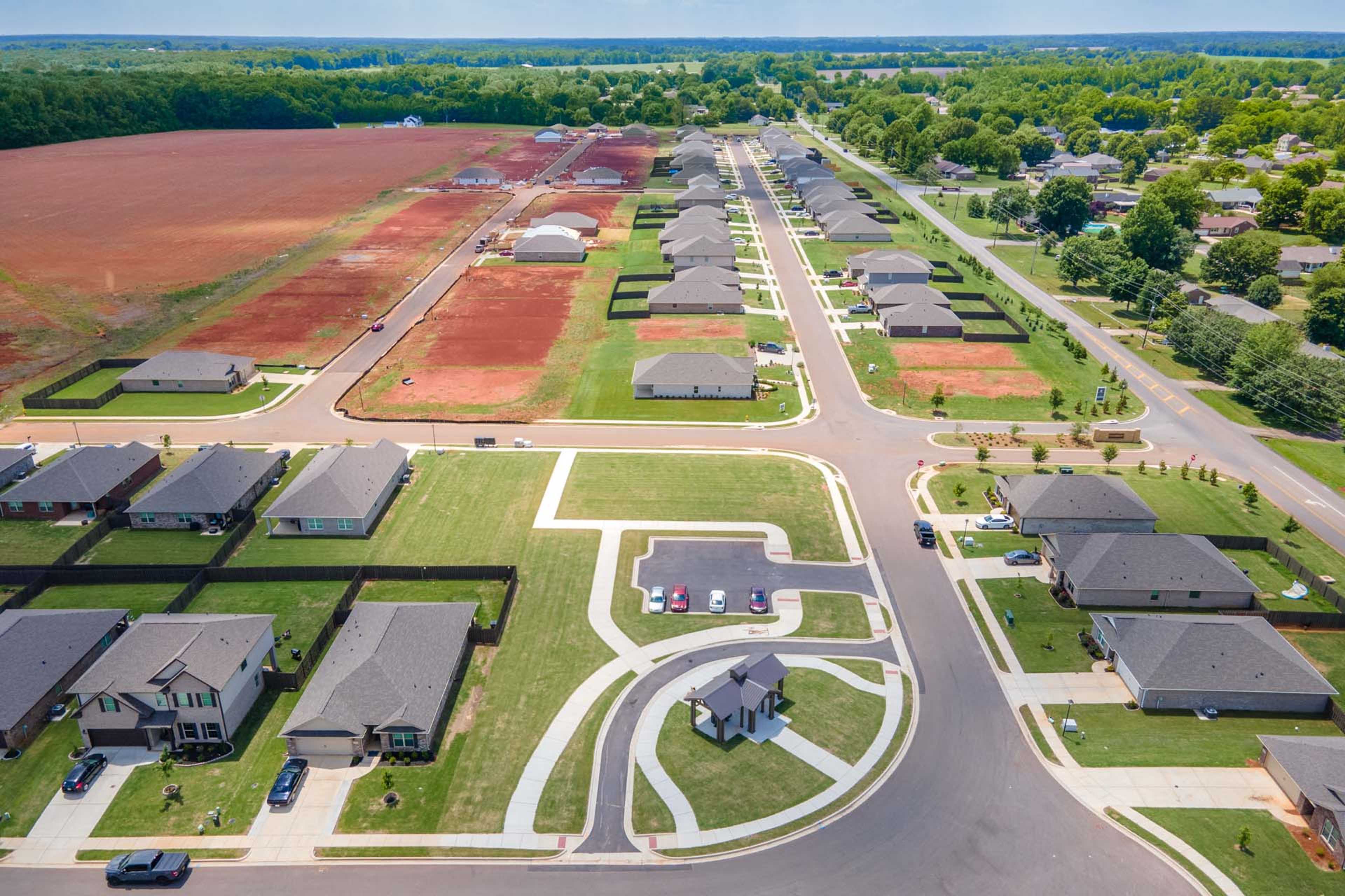 Aerial view of Clearview neighborhood in Hazel Green Alabama by Davidson Homes featuring new single-family homes, streets, red clay lots and green fields