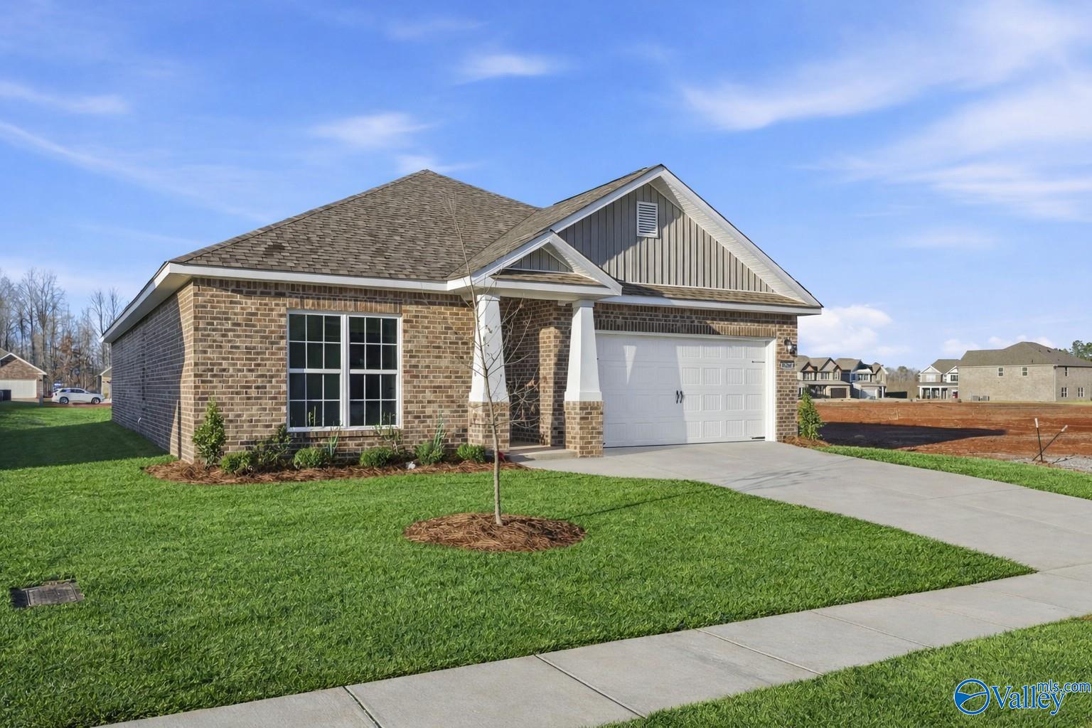 Brick single-story home with gabled roof, 2-car garage, covered entry, and landscaped yard in Ricketts Farm, Athens, Alabama - Davidson Homes The Daphne C
