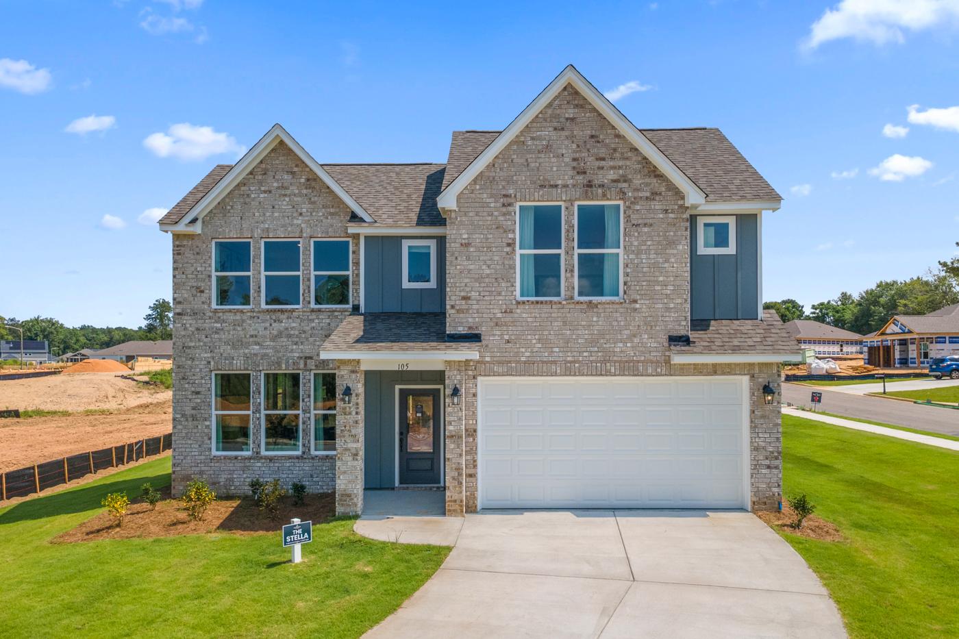 The Stella floor plan by Davidson Homes at Links Crossing in Auburn, Alabama, featuring a brick exterior and two-car garage.