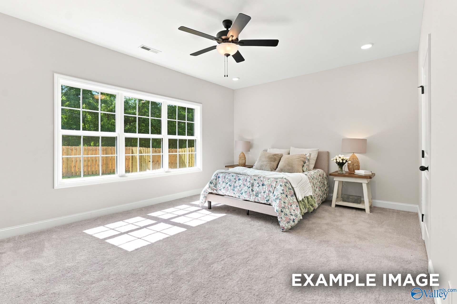 Bright, spacious bedroom with ceiling fan and large windows in The Montgomery B floor plan at The Meadows, Athens, AL.