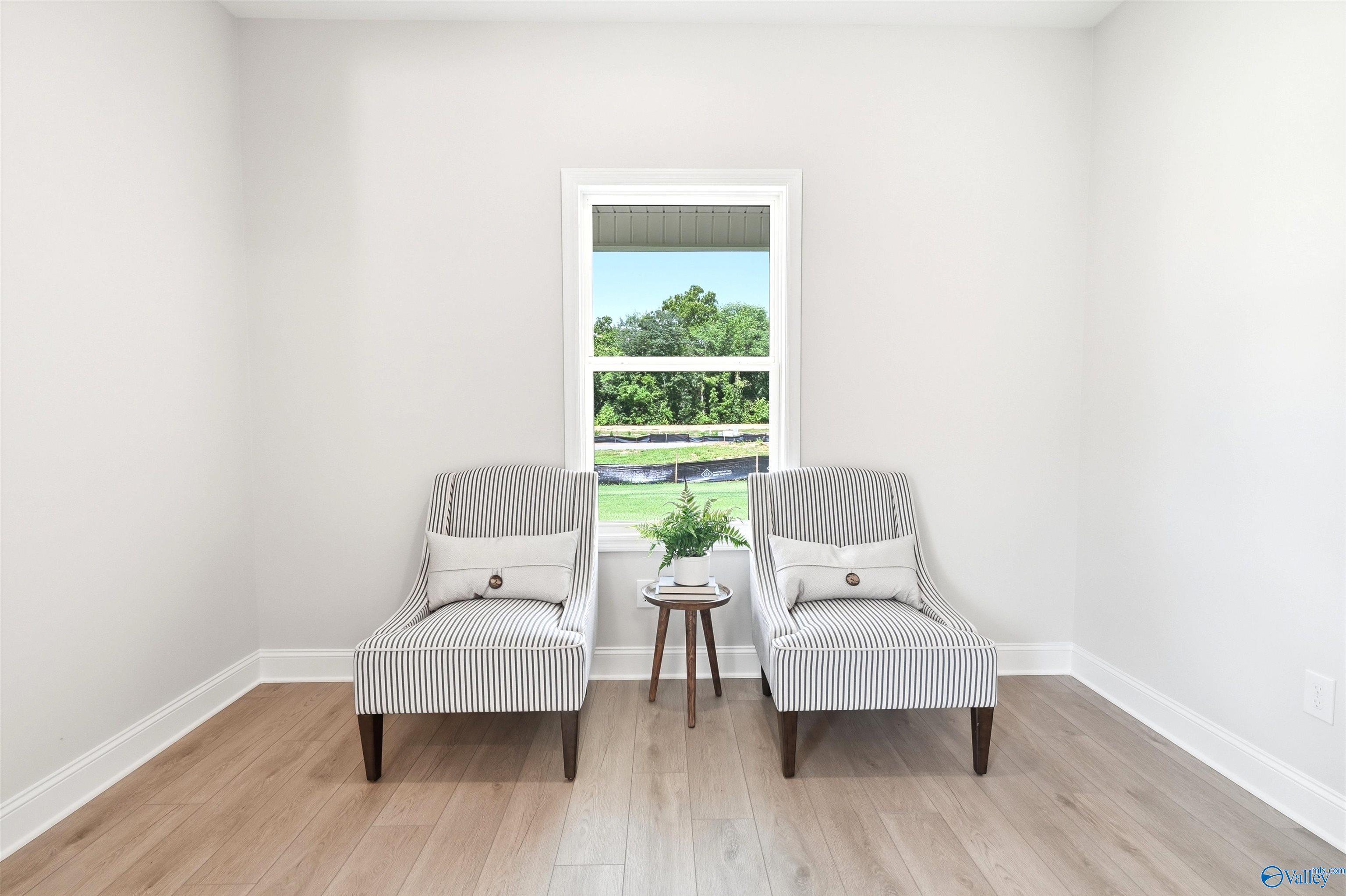 Bright seating nook with striped accent chairs and hardwood floors in Davidson Homes The Russell A plan, Huntsville, AL