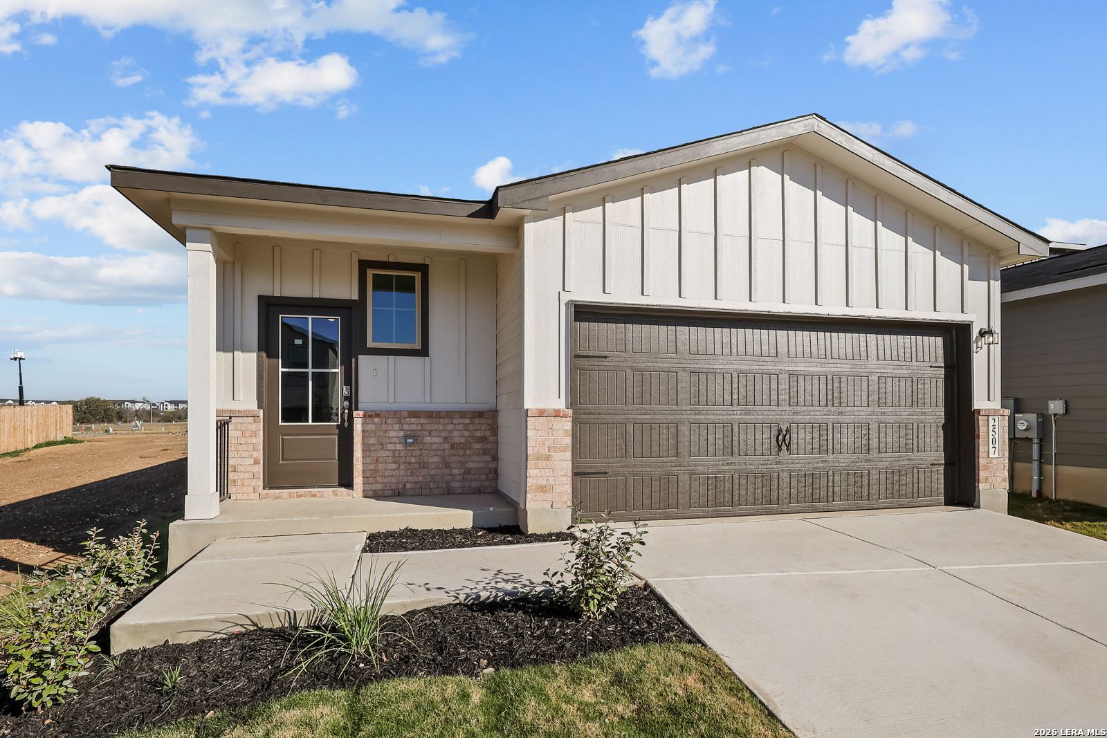 Modern 1-story ranch home exterior with 2-car garage, brick accents, and front porch in Applewhite Meadows, San Antonio, Texas