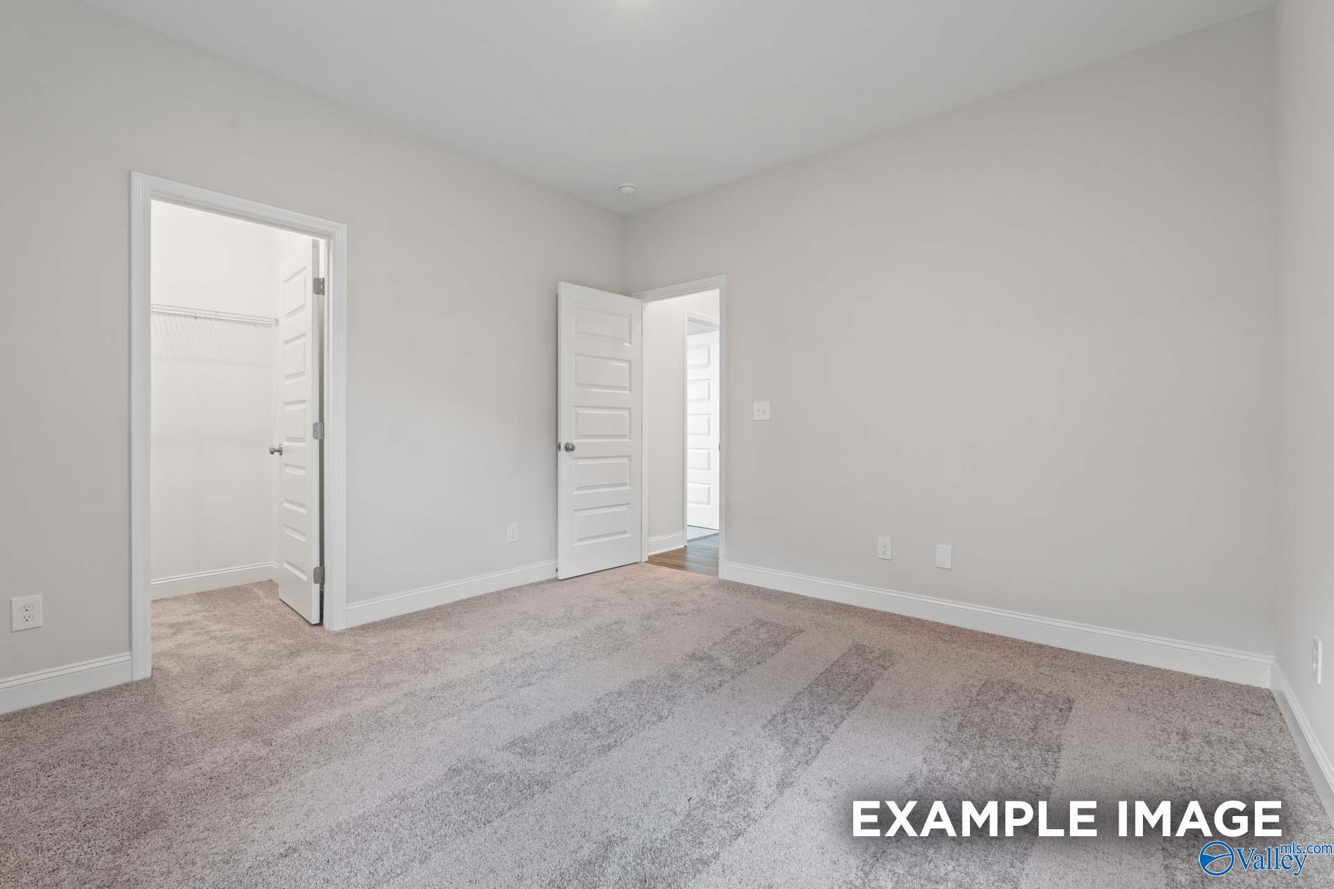 Spacious secondary bedroom with open walk-in closet and adjoining bath door in Davidson Homes The Montgomery, Hartselle AL