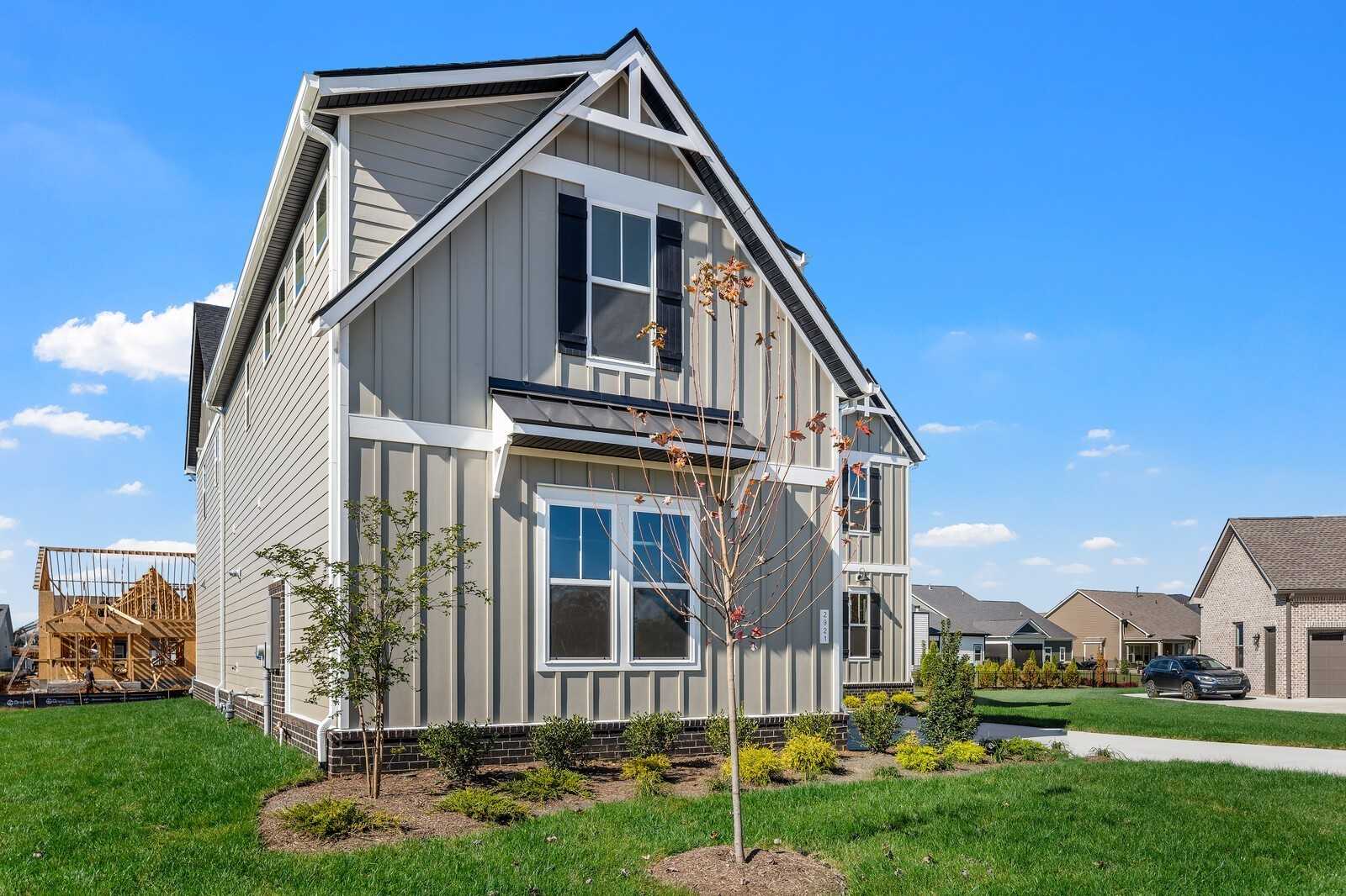 Two-story gray home with gabled roof, white trim, front yard landscaping, and driveway in Shelton Square, Murfreesboro, Tennessee
