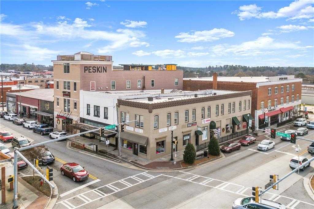 Vibrant Winder Georgia street corner with historic brick buildings, shops, and traffic in Cedar Farms area near Davidson Homes