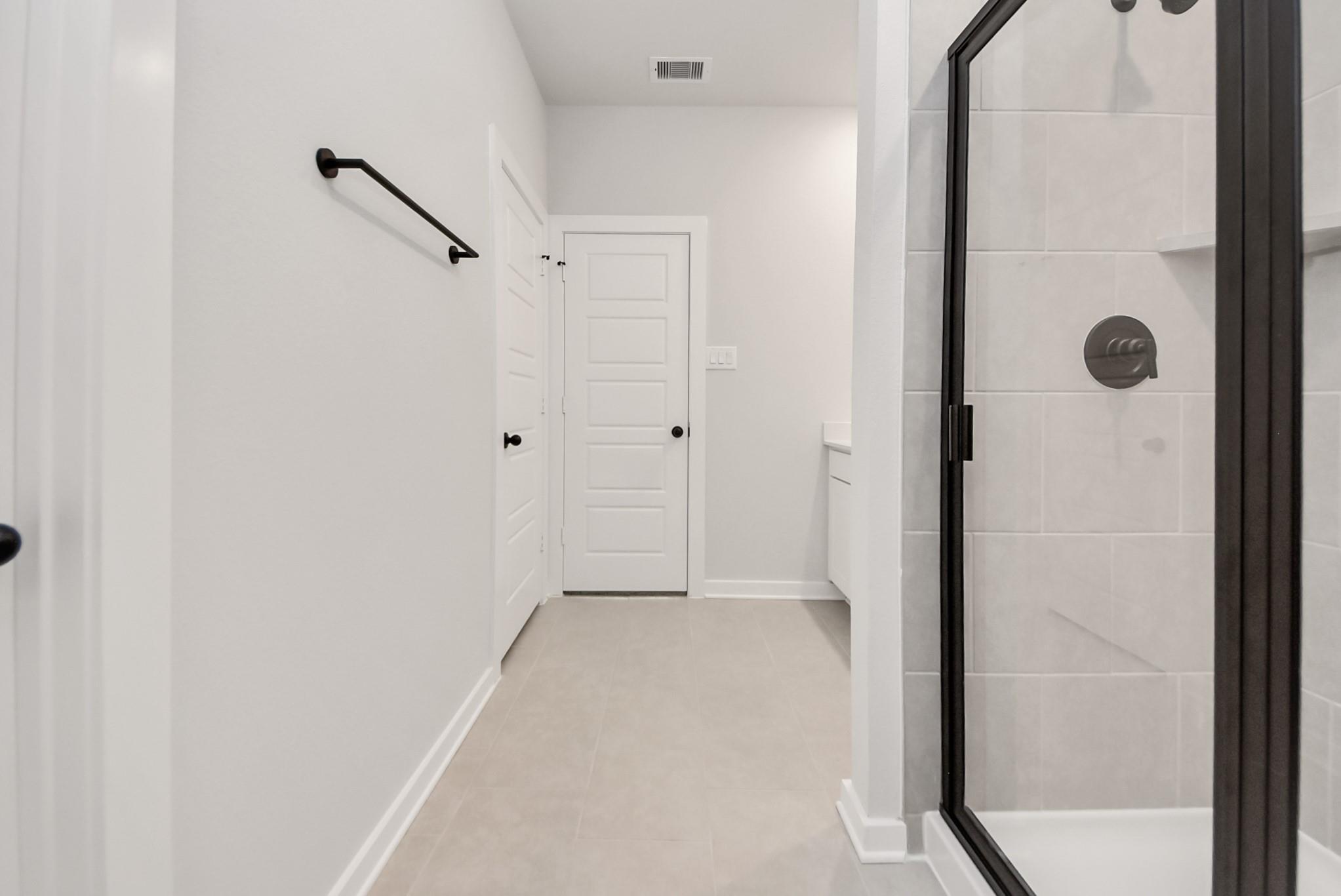 Modern bathroom with glass-enclosed shower in The Daphne F floor plan at Sundance Cove, Crosby, Texas.