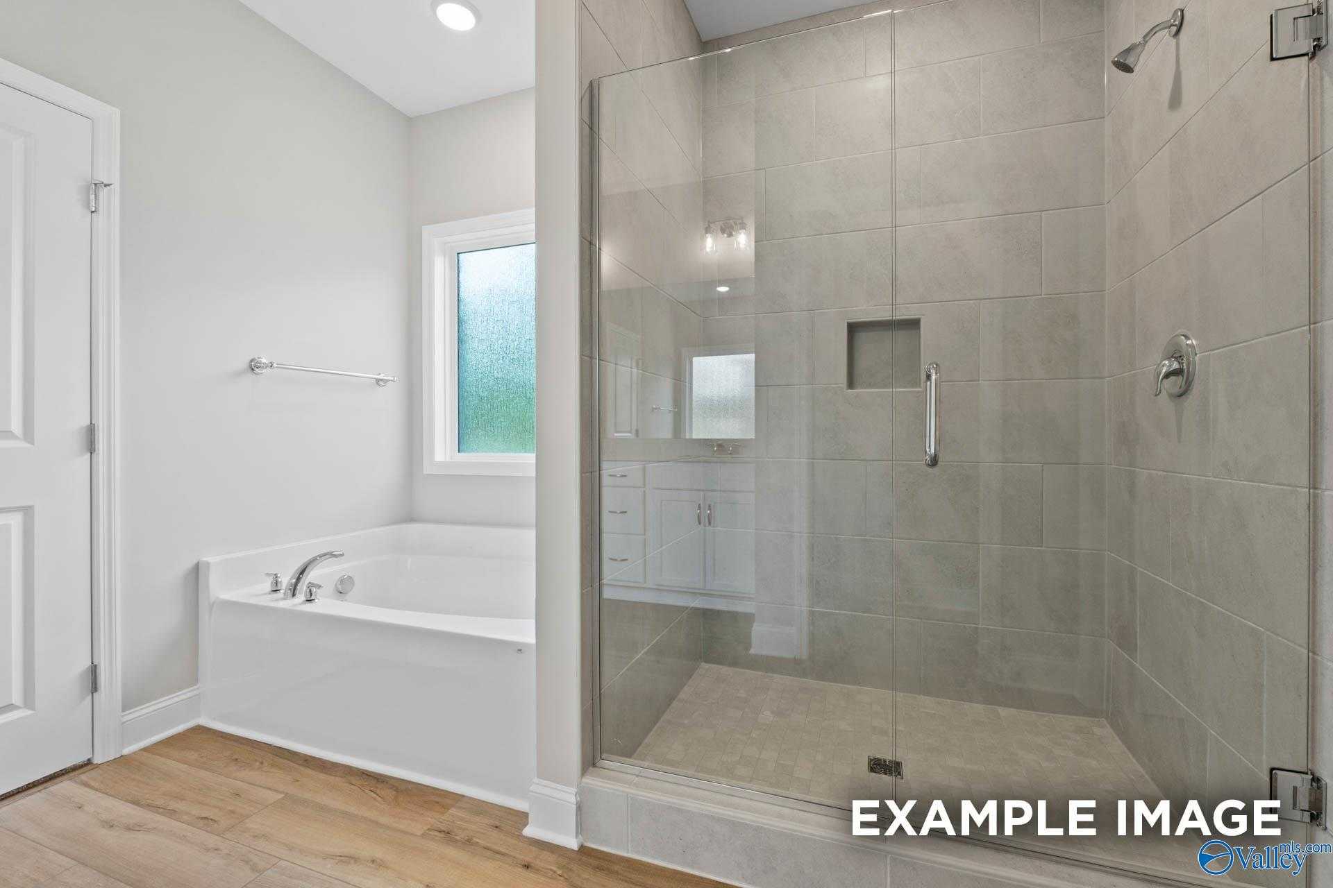 Spa-like master bathroom featuring frameless glass shower, soaking tub, and dual vanities in Davidson Homes The Everett, Meridianville, AL