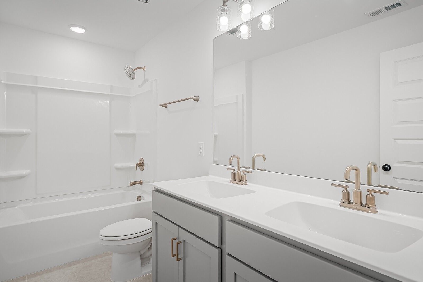 Modern bathroom with double vanity, gold fixtures, bathtub, and shower in Davidson Homes The Logan C, Gallatin, TN