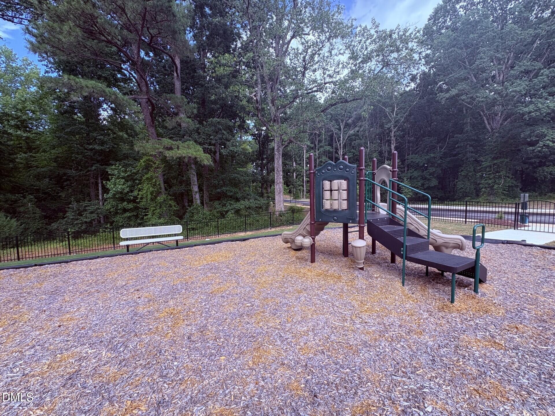 Community playground with climbing structure and bench at Woodland Crossing in Zebulon, North Carolina.
