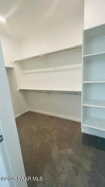 Walk-in closet with built-in shelving and hanging rods in The Summit A floor plan by Davidson Homes, Prescott, Arizona.
