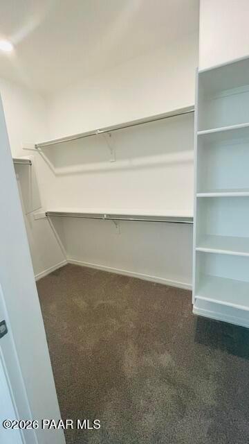 Walk-in closet with built-in shelving and hanging rods in The Summit A floor plan by Davidson Homes, Prescott, Arizona.