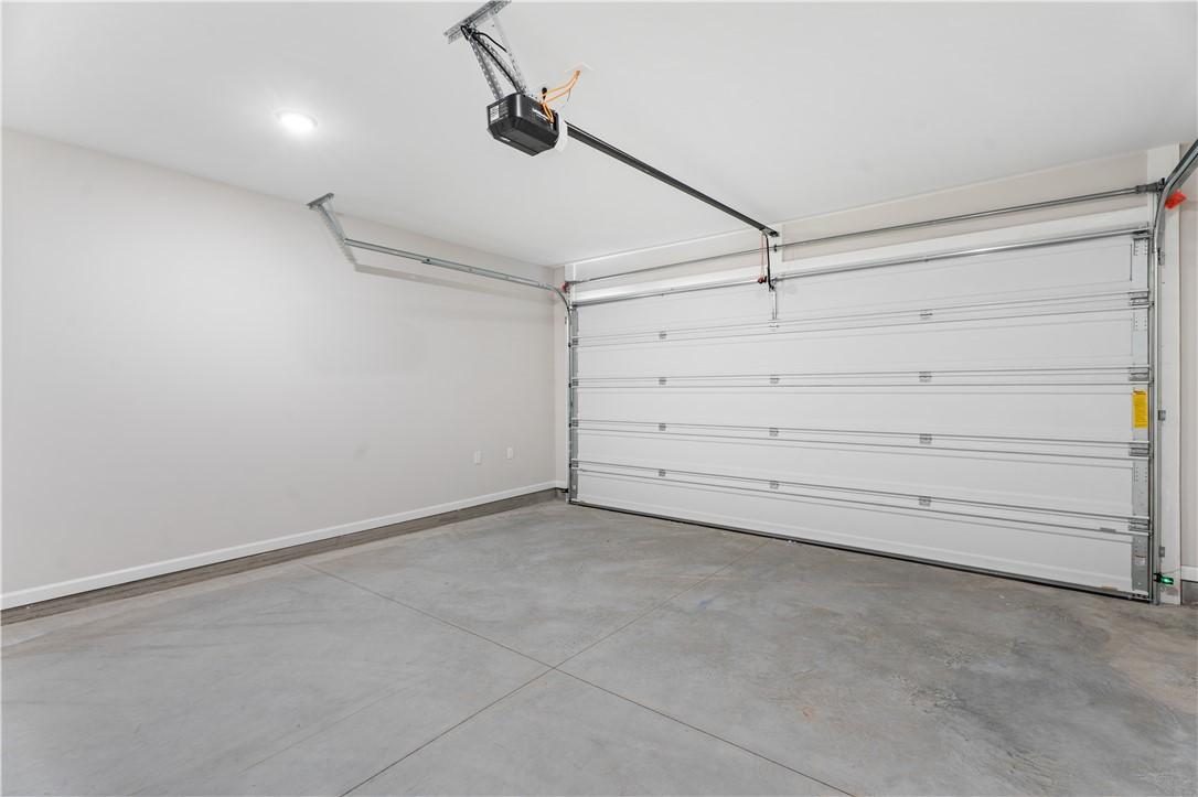 Spacious empty two-car garage with open white door and overhead opener in Davidson Homes The Luna B, Opelika, Alabama