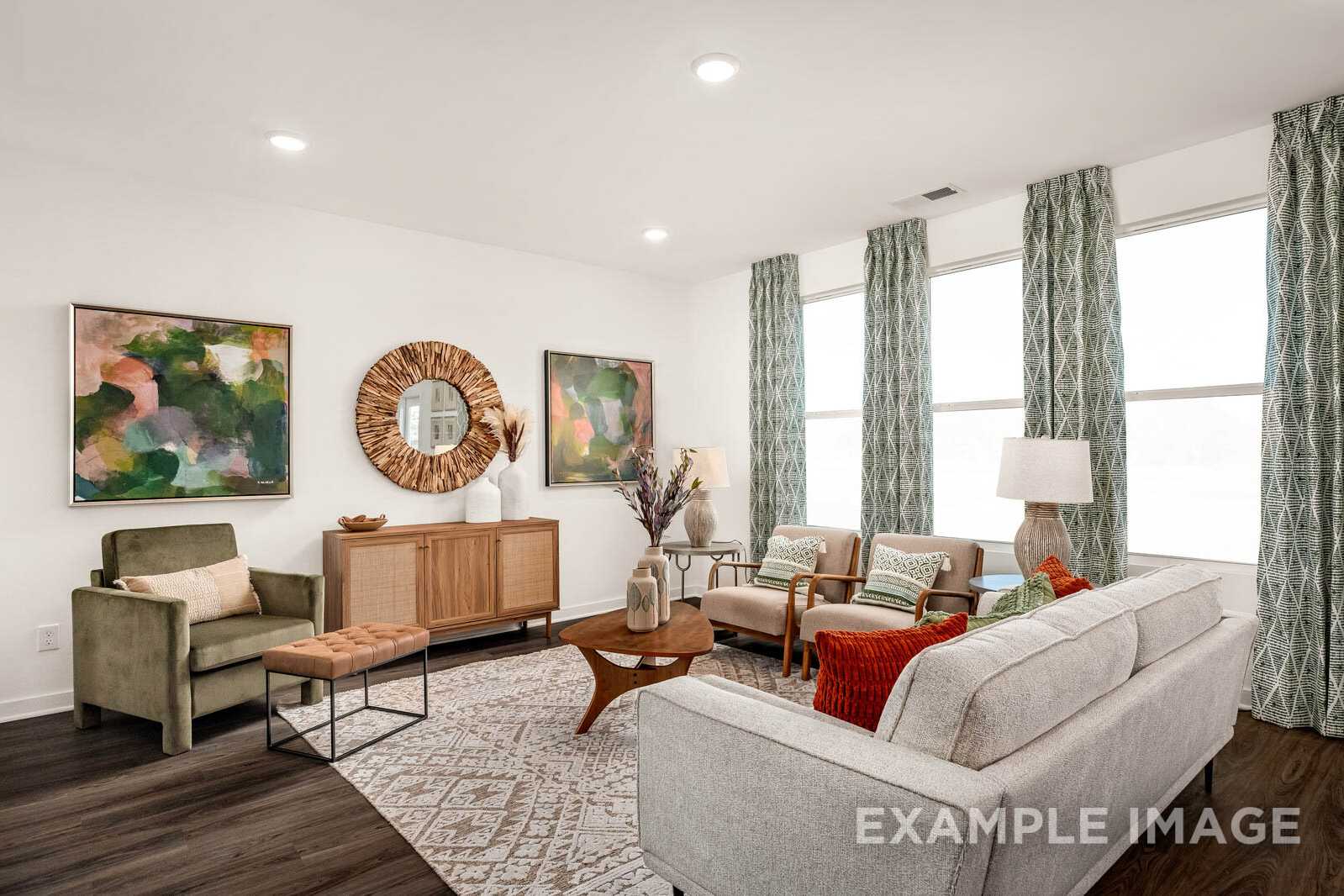 Modern living room in The Gordon B home design with neutral furniture, abstract art, rattan accents, and large green-curtained windows