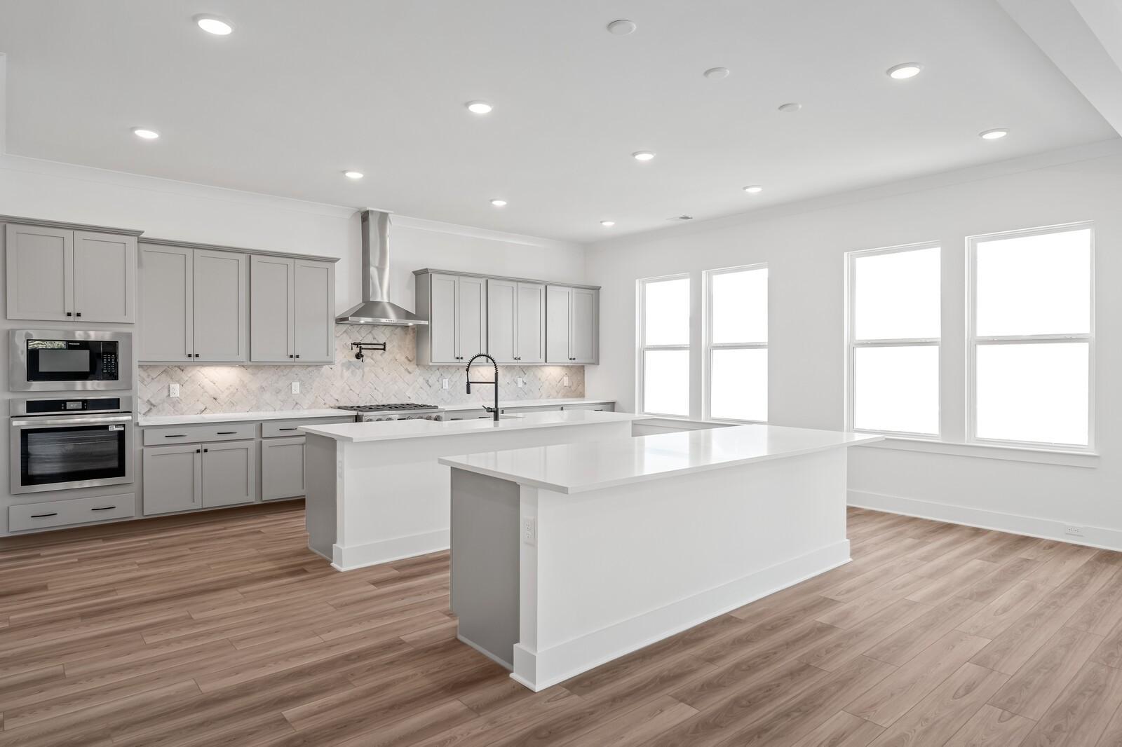 Open-concept kitchen with gray shaker cabinets, white quartz island, stainless appliances in Davidson Homes The Alston A, Murfreesboro, TN