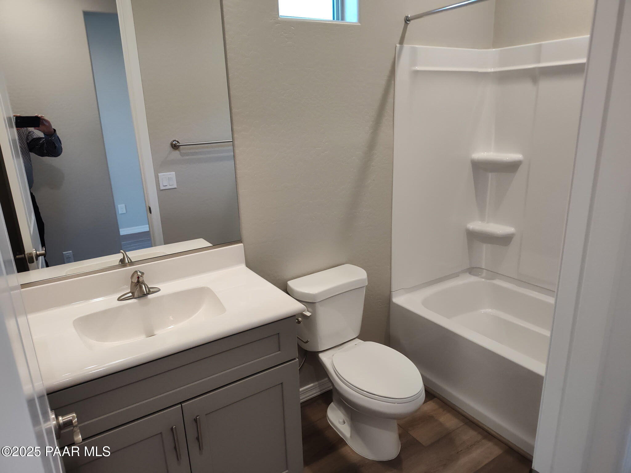 Modern bathroom featuring gray vanity sink, bathtub shower combo, and wood-look flooring in Davidson Homes The Frontier C, Prescott Valley, Arizona