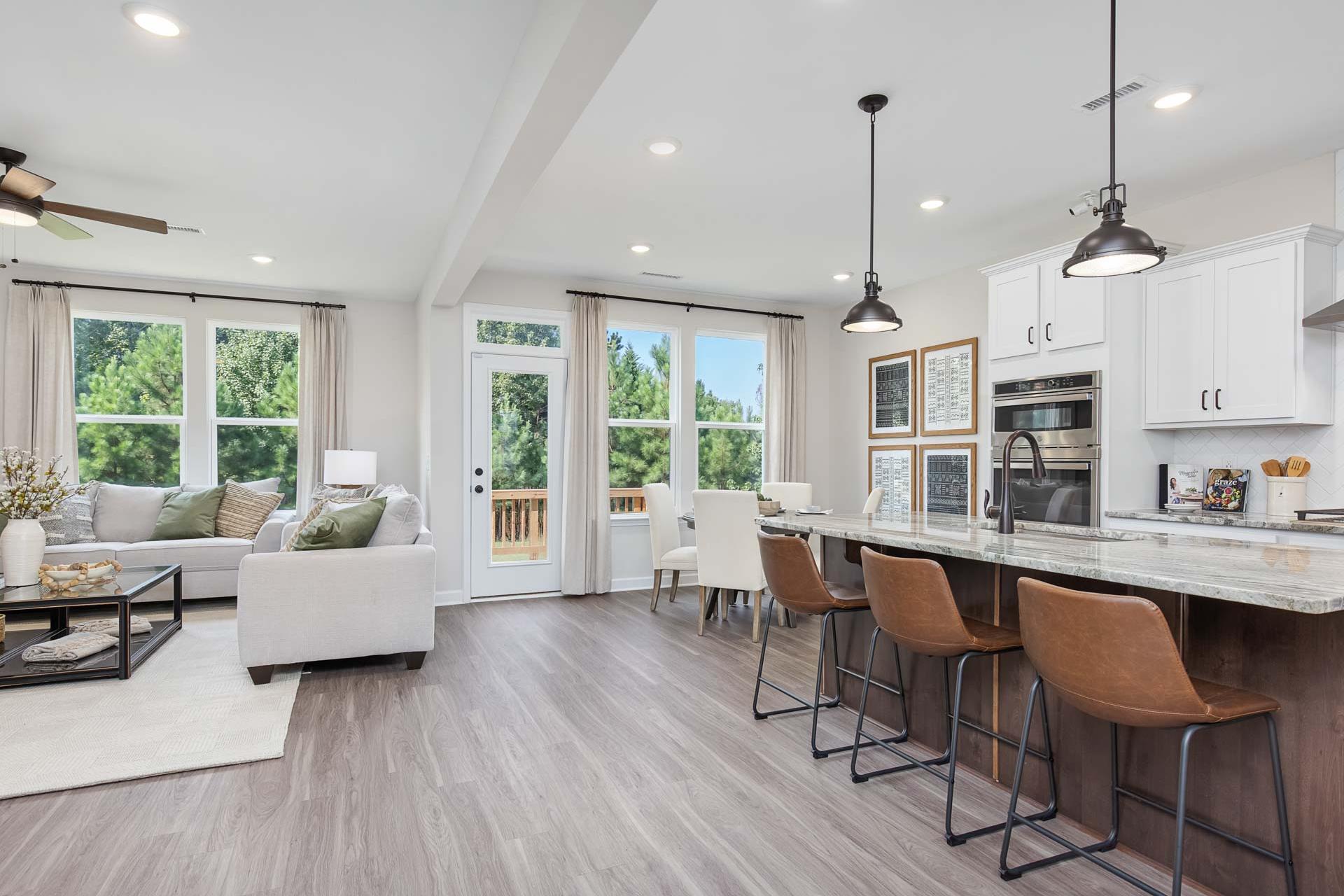 Spacious open-concept kitchen and living area at Sierra Heights in Clayton NC with hardwood floors, large windows, and modern island