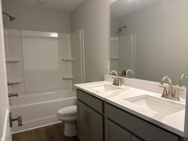 Modern master bathroom with double vanity, soaking tub, separate shower, and gray cabinetry in Davidson Homes Marion A, Winder, GA