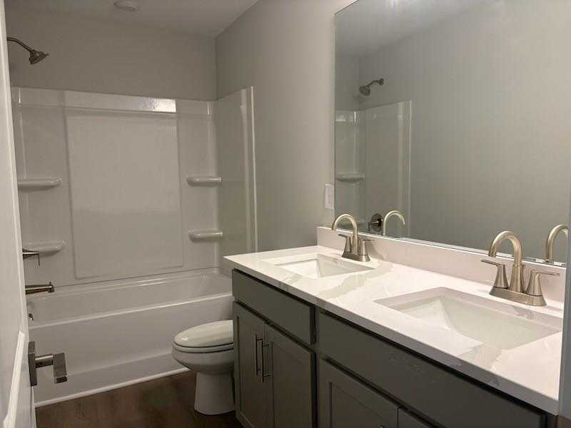 Modern master bathroom with double vanity, soaking tub, separate shower, and gray cabinetry in Davidson Homes Marion A, Winder, GA