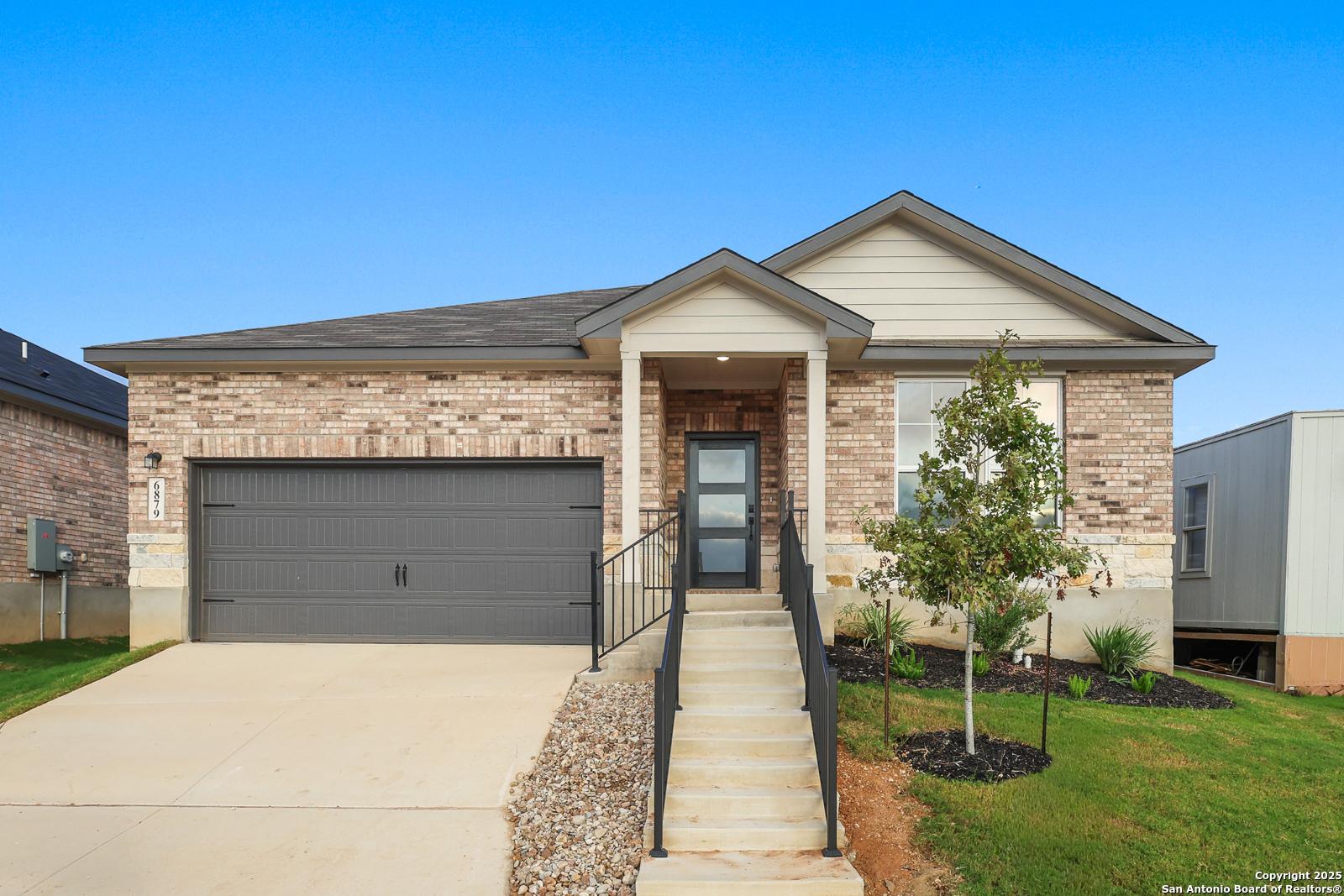 Modern single-story brick home with 2-car garage, covered entry porch, and front steps in Comanche Ridge, San Antonio, Texas - Davidson Homes Daphne K