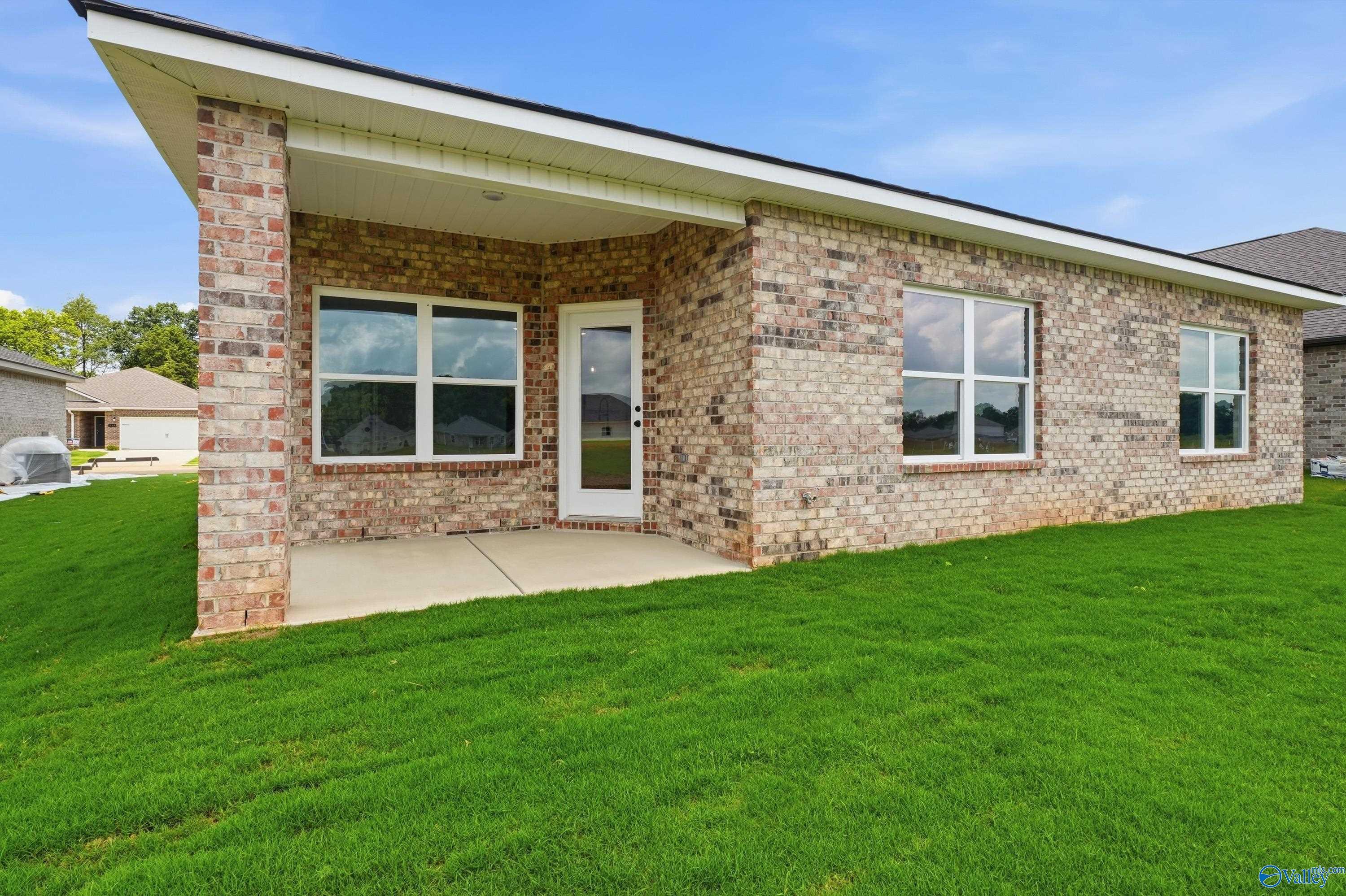 Covered back patio and brick exterior of The Daphne floor plan in Lynn Meadows, Meridianville, Alabama.