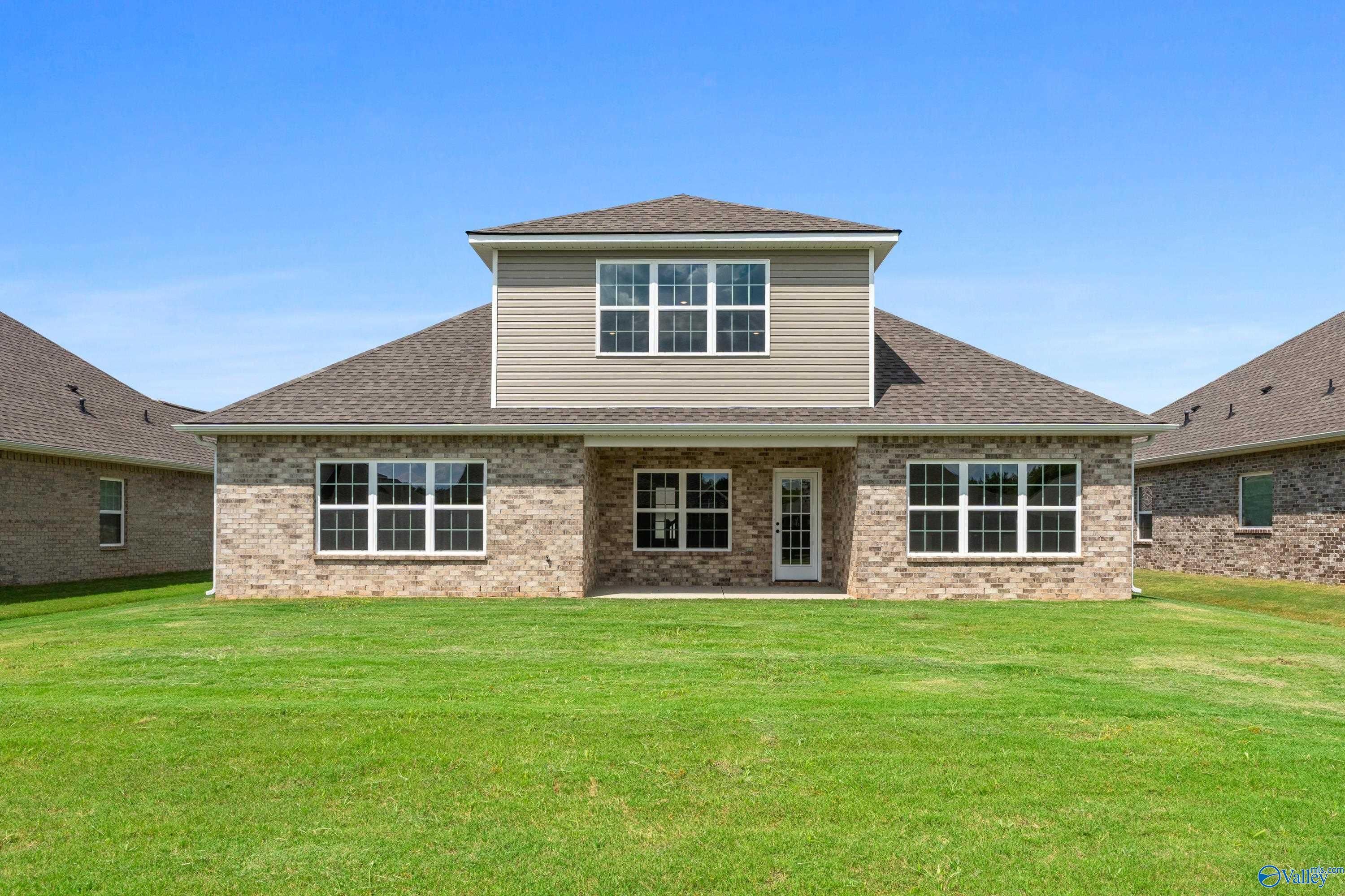 1.5-story Davidson Homes Montgomery B With Bonus front exterior: brick and beige siding, large windows, attached garage, green lawn in Kendall Downs, Toney, AL