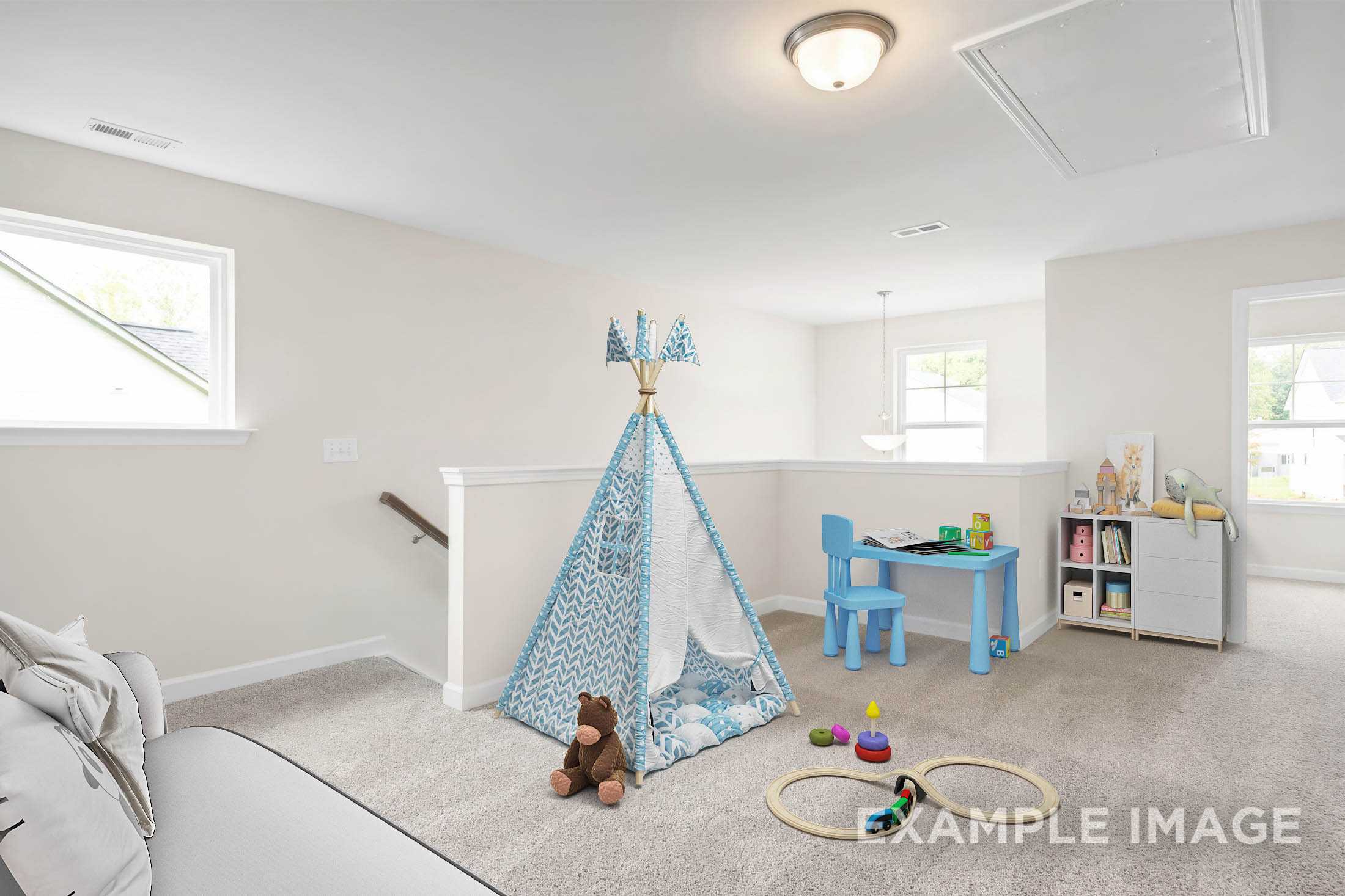 Spacious bonus room in The Gavin C home featuring blue play tent, teddy bear, kids' table, toys, and bookshelves on carpeted floor