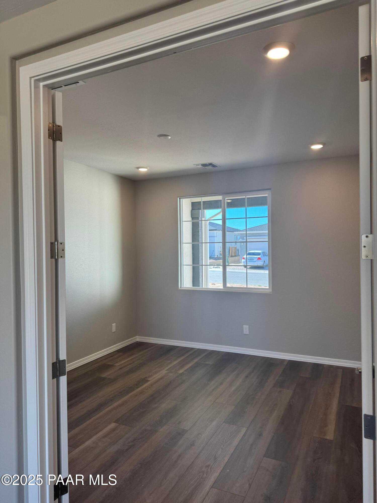 Spacious empty bedroom with hardwood floors, large window overlooking Prescott landscape in Davidson Homes The Monarch E