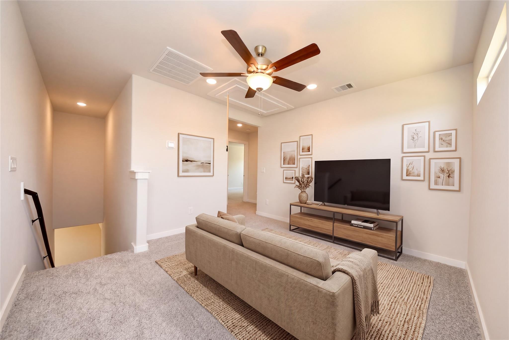 Cozy upstairs loft with TV, sofa, and modern decor in The Sabine E floor plan at Windmill Estates, Magnolia, Texas.