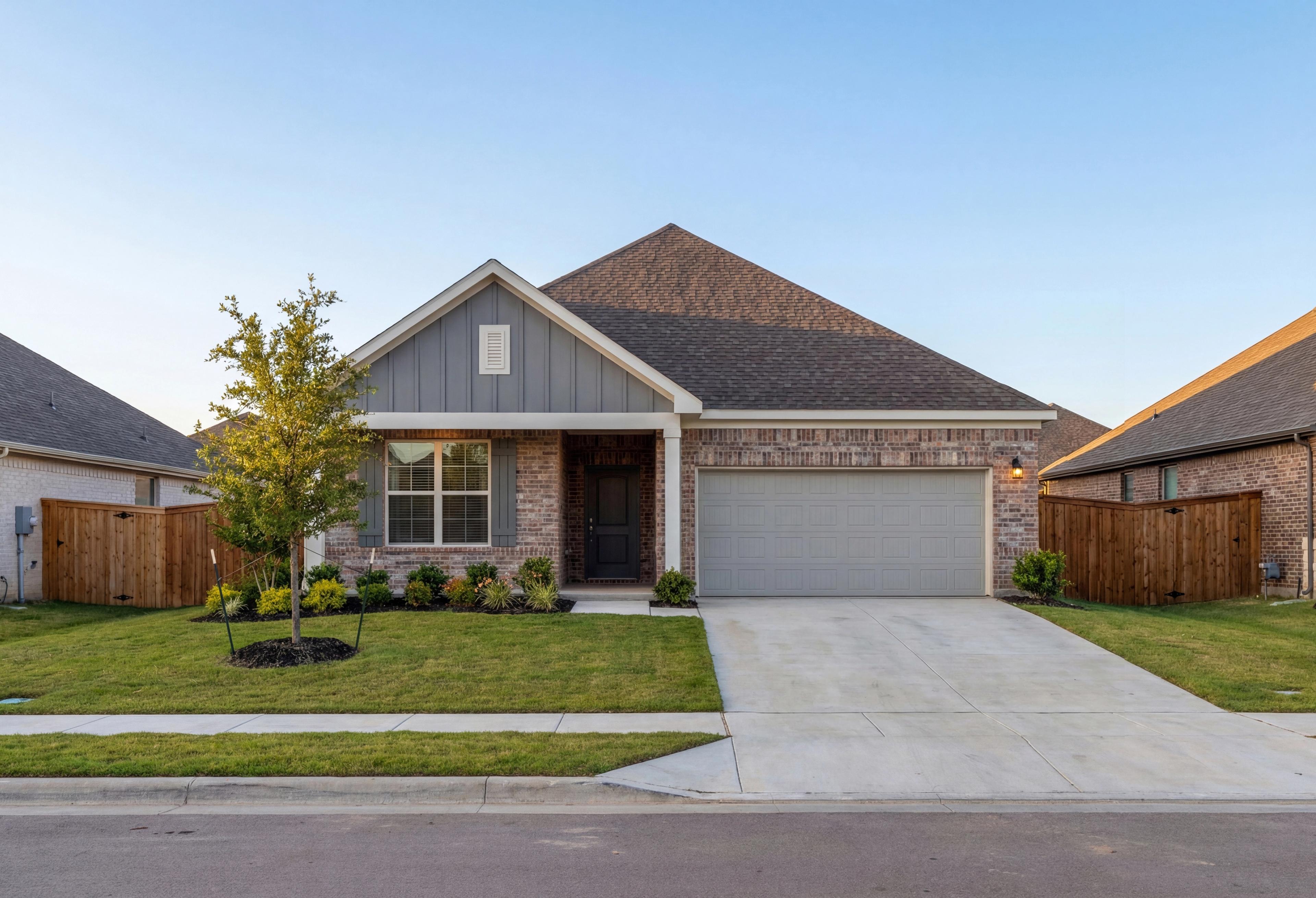Modern single-story Everett home elevation featuring brick facade, gray siding, peaked roof, 2-car garage, and landscaped front yard