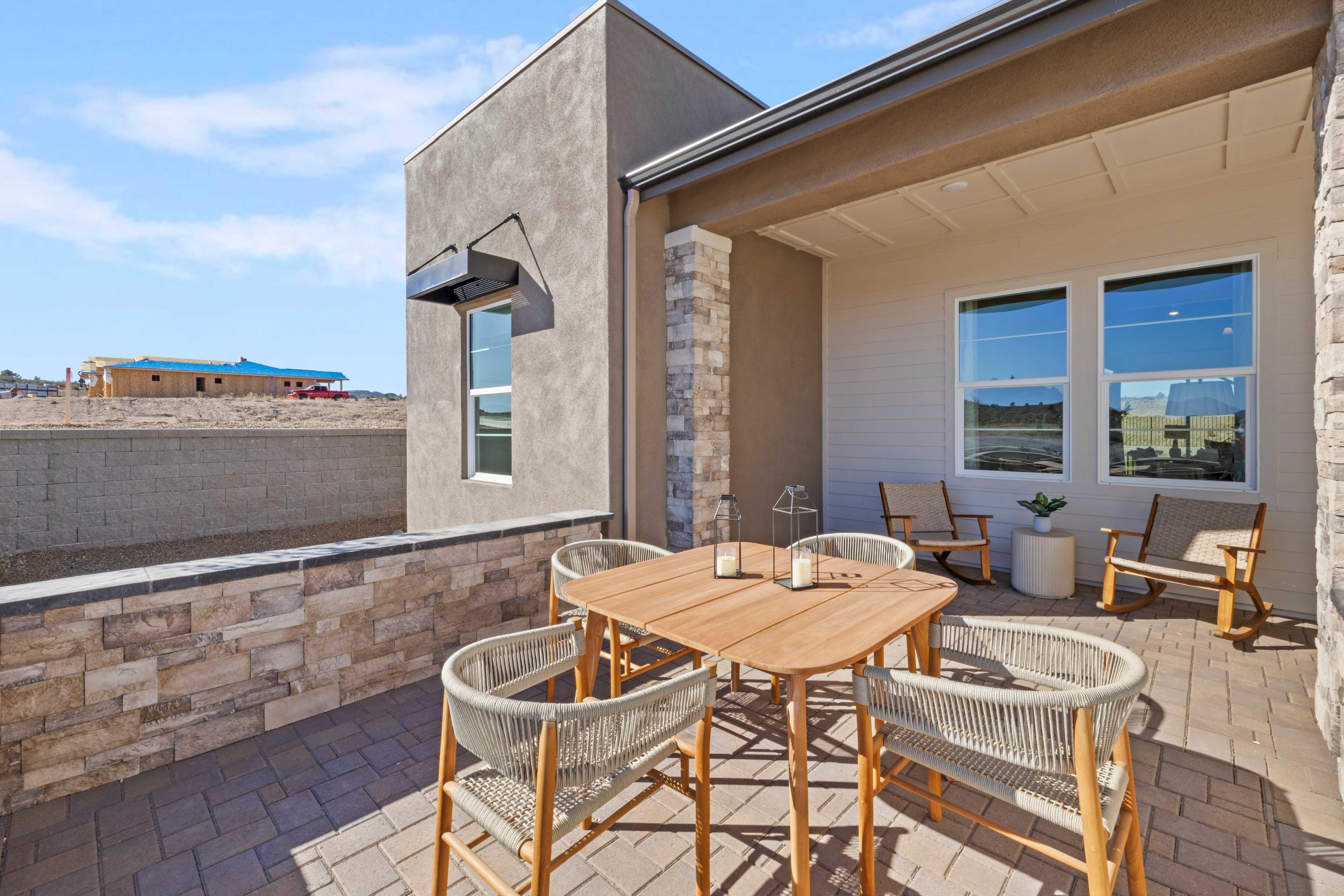 Covered patio with teak dining set and potted plants at Hidden Hills in Prescott AZ by Davidson Homes, desert views