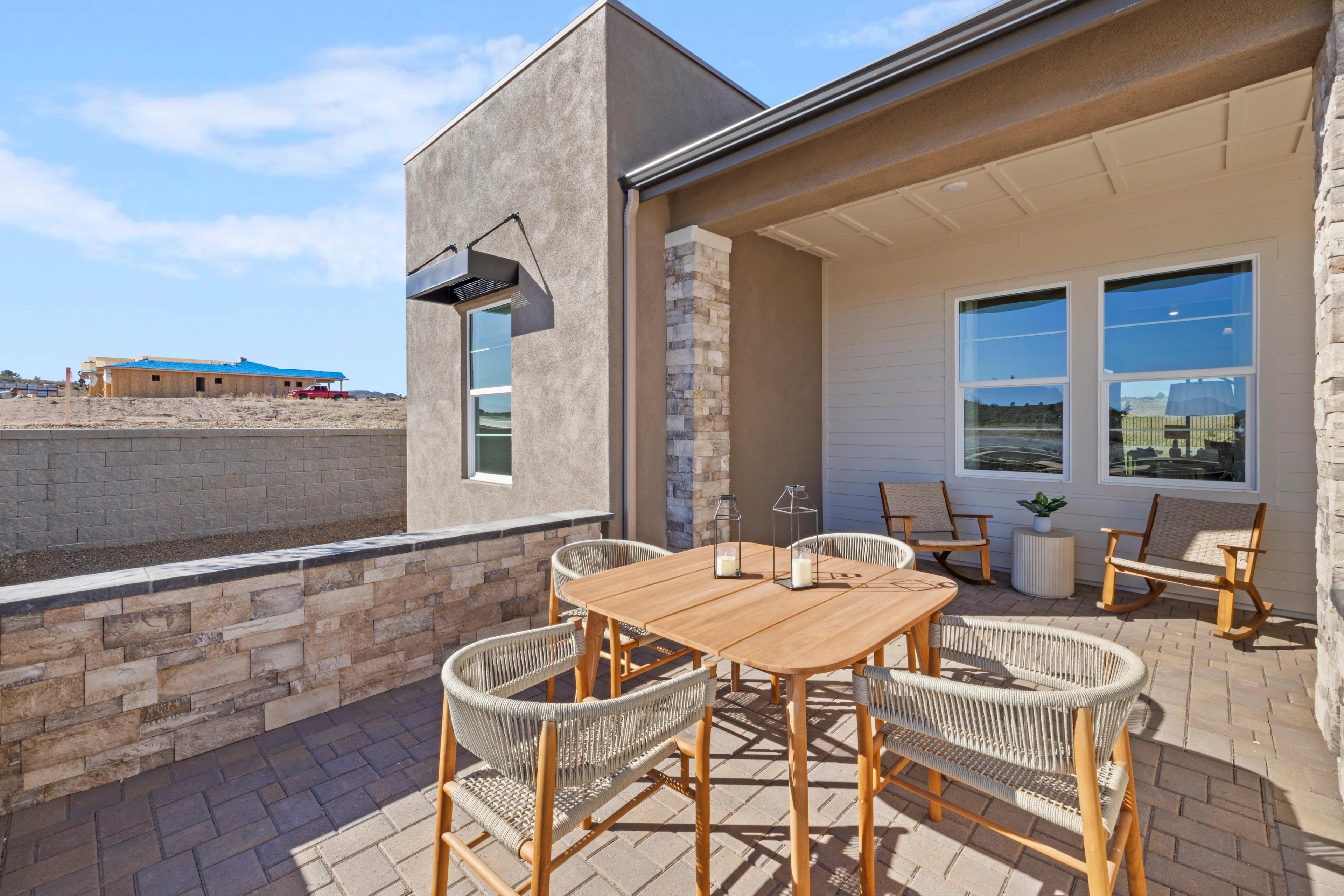 Covered patio with teak dining set and potted plants at Hidden Hills in Prescott AZ by Davidson Homes, desert views