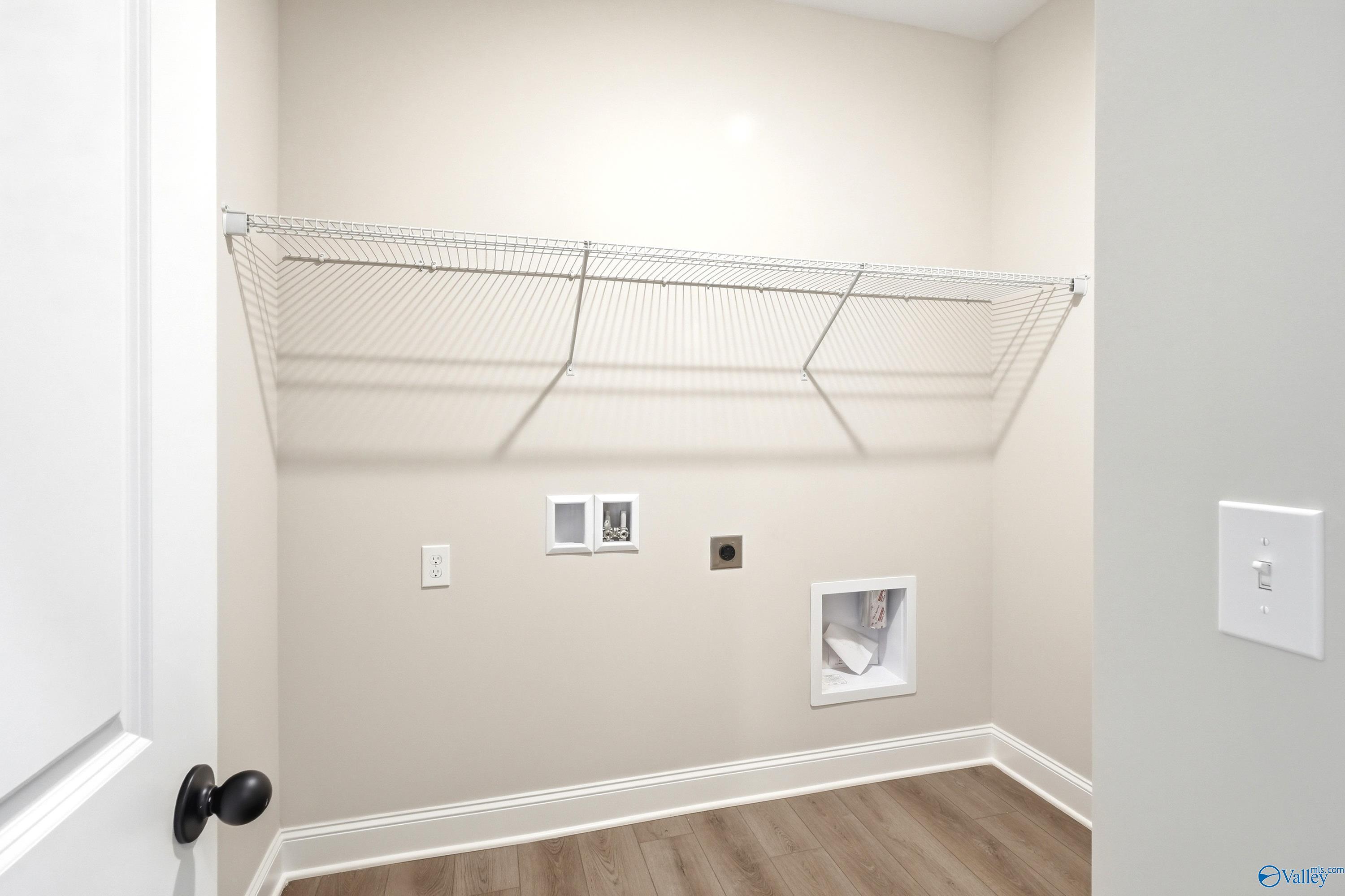Laundry room with wire shelving and utility hookups in The Daphne floor plan at Lynn Meadows, Meridianville, Alabama.