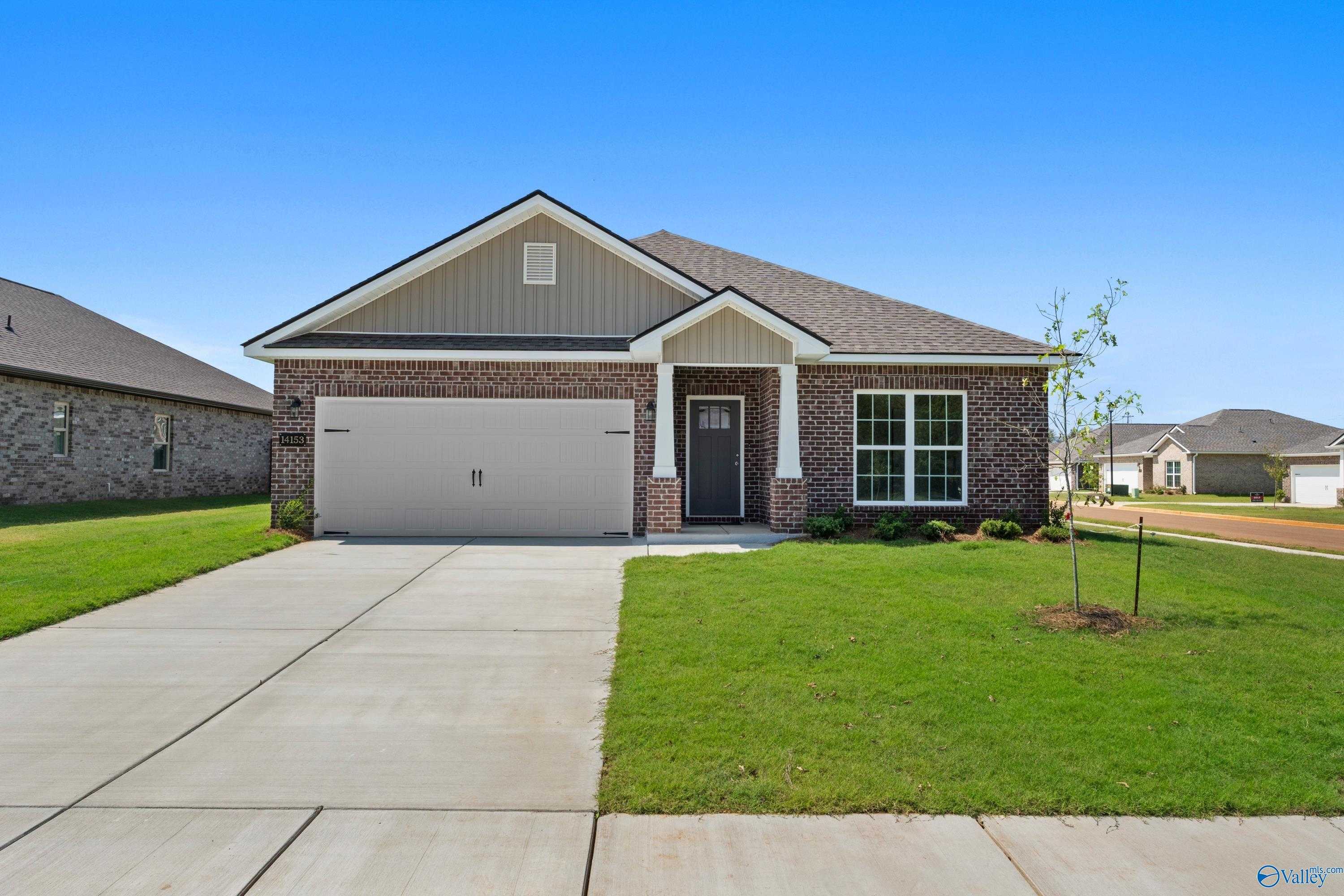 Modern single-story 4-bedroom home with 2-car garage, brick accents, and lush lawn in The Meadows, Athens, Alabama