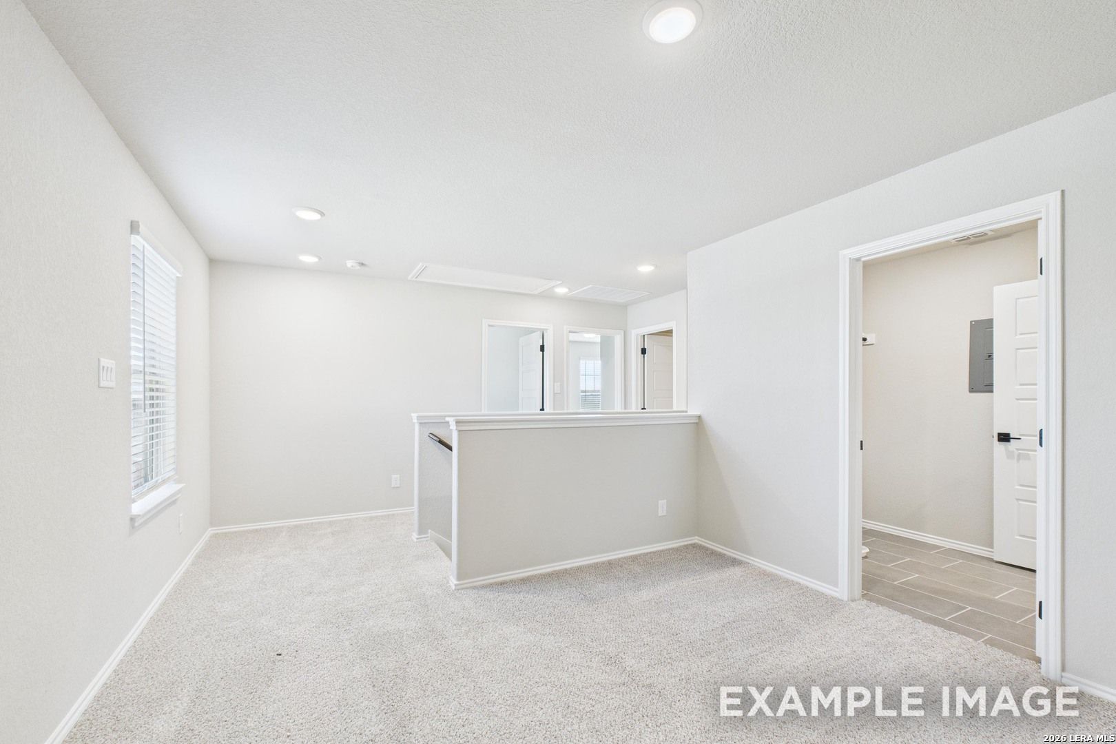 Bright carpeted upstairs loft in The Charlotte B floor plan by Davidson Homes in Cedar Heights, San Antonio, Texas.