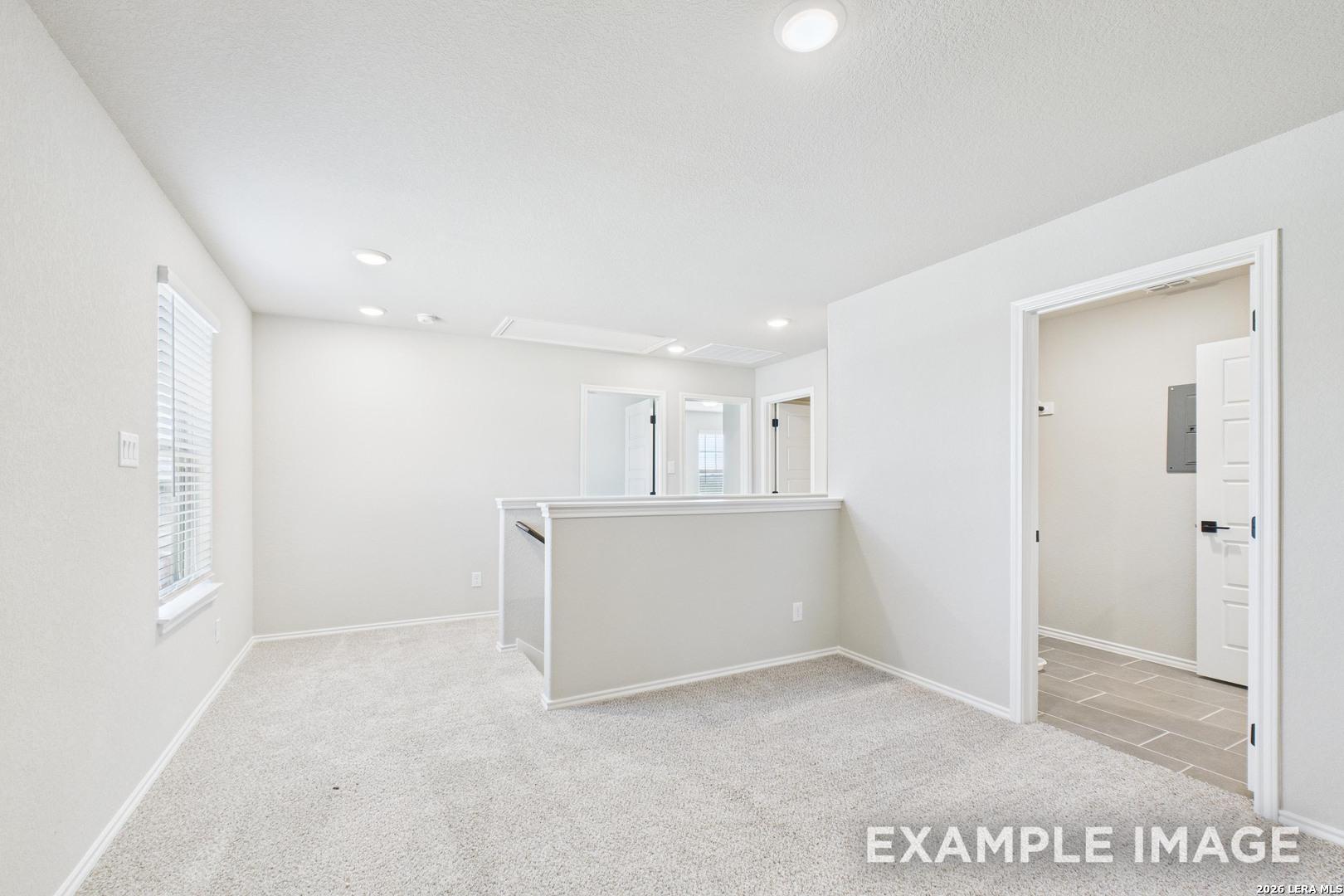 Bright carpeted upstairs loft in The Charlotte B floor plan by Davidson Homes in Cedar Heights, San Antonio, Texas.